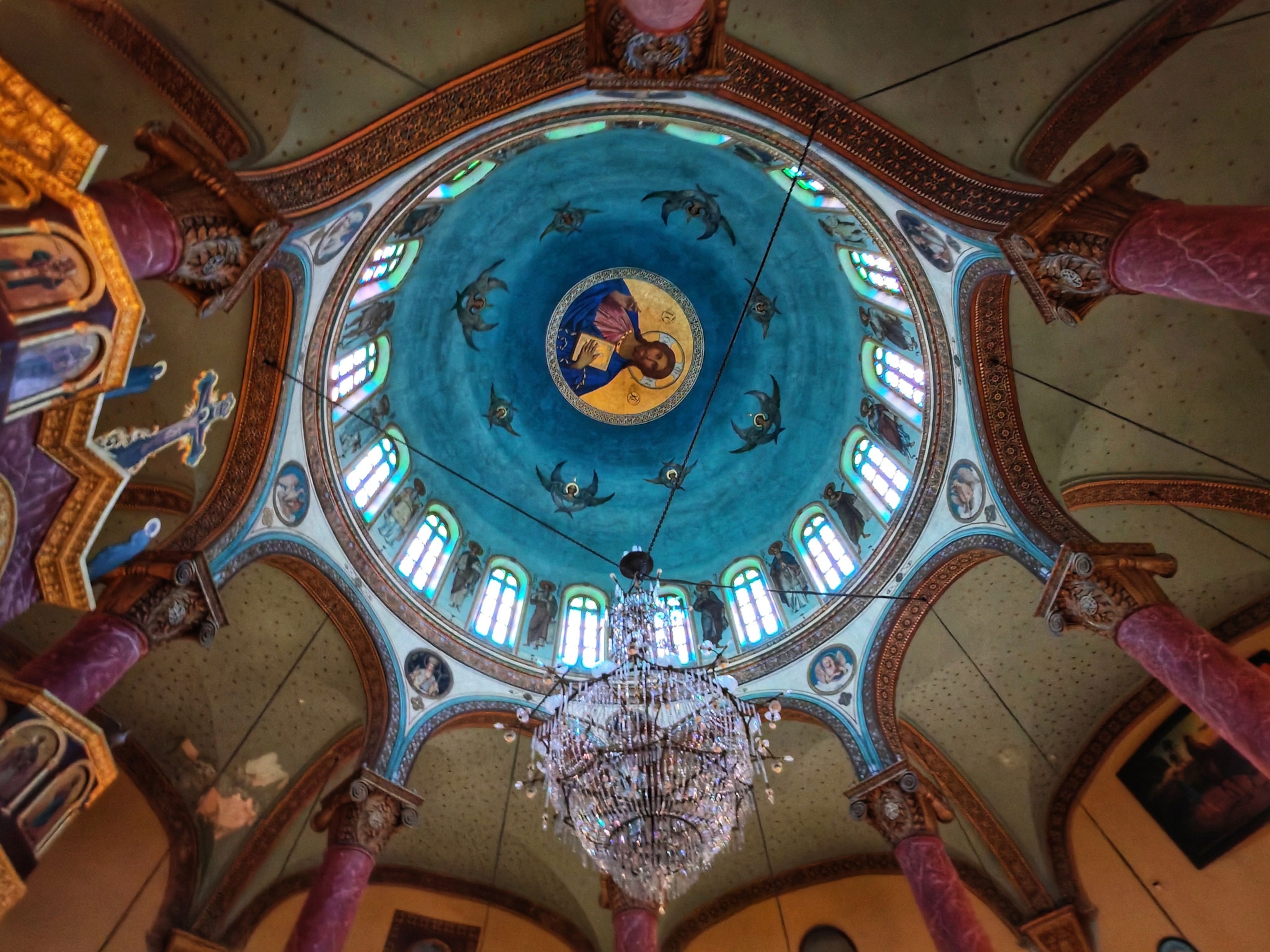 Ornate and colorful interior ceiling of the rebuilt Monastery of St. George in the Coptic Quarter of Cairo, depicting Christian icons.