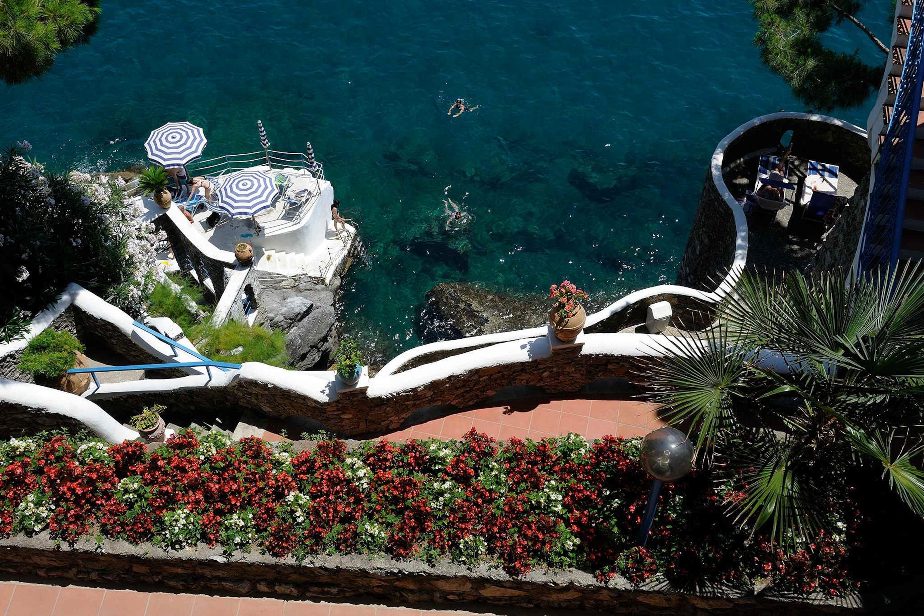 A winding terracotta path leads from the hotel to the sea.