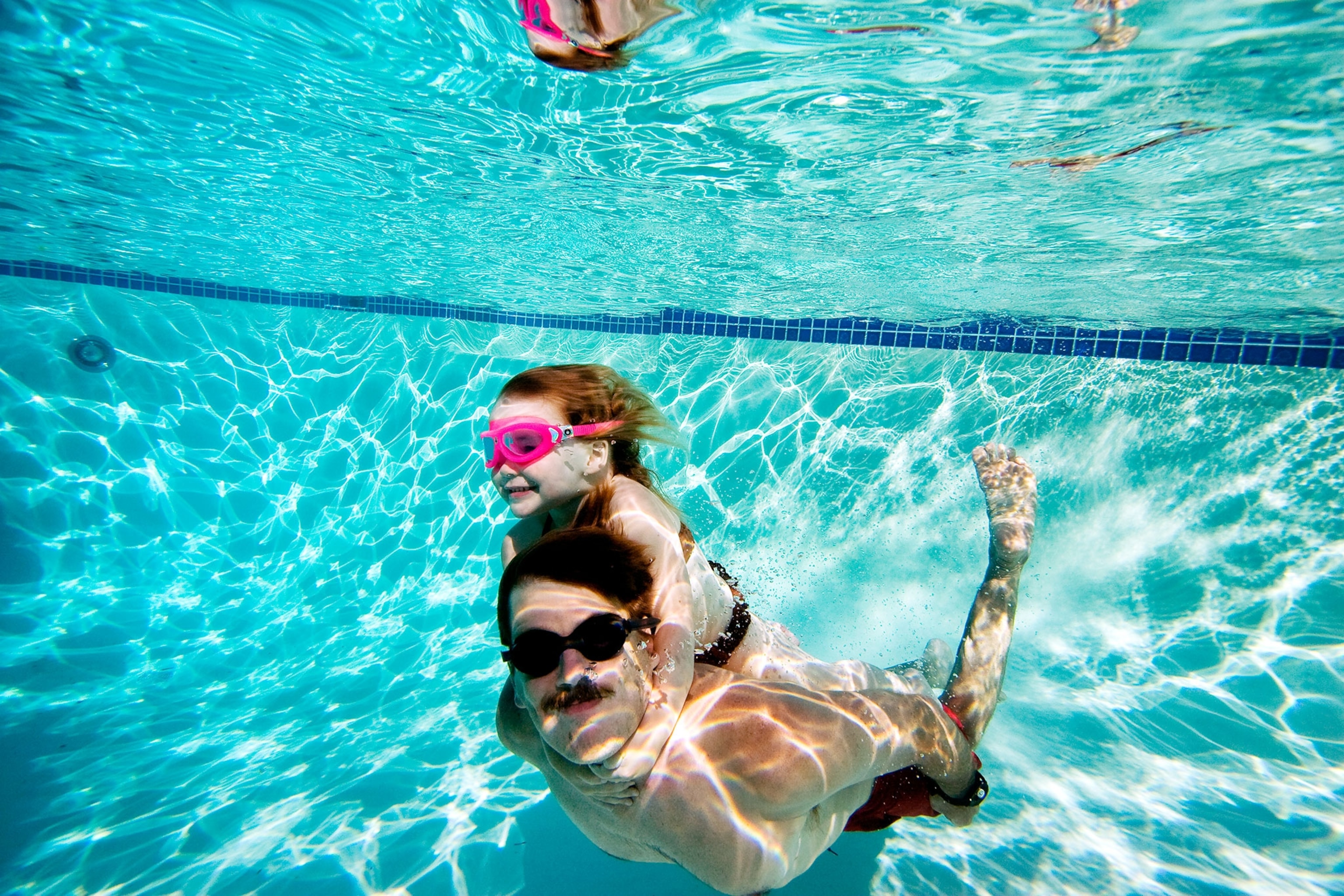 father swimming with daughter