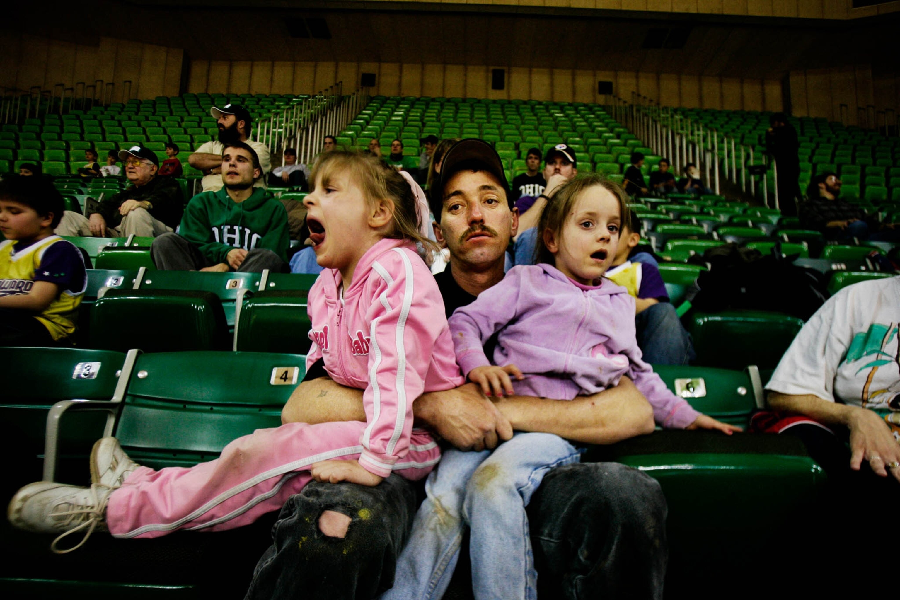 father struggling to wrangle girls at basketball game