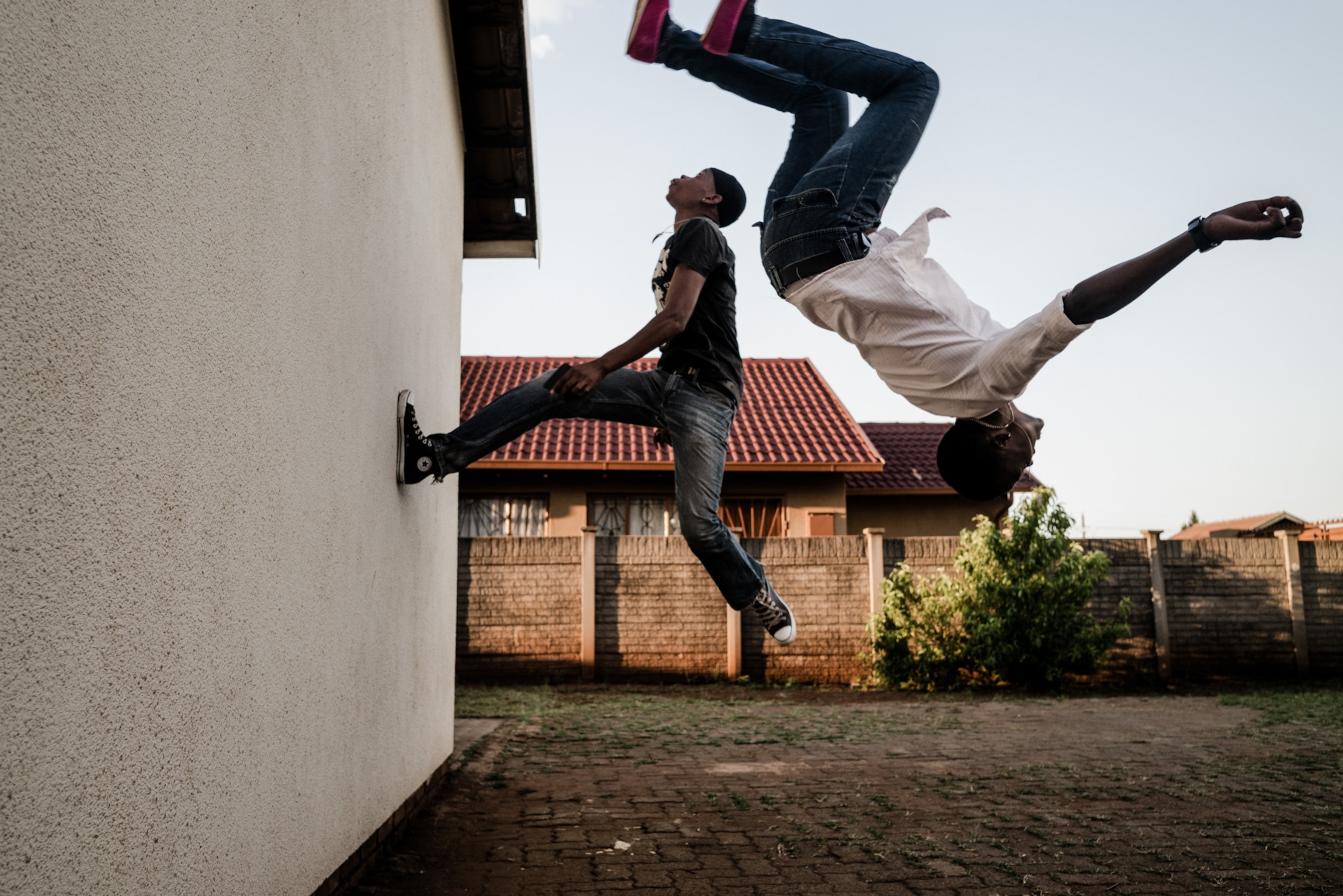 two men flipping off of a wall.