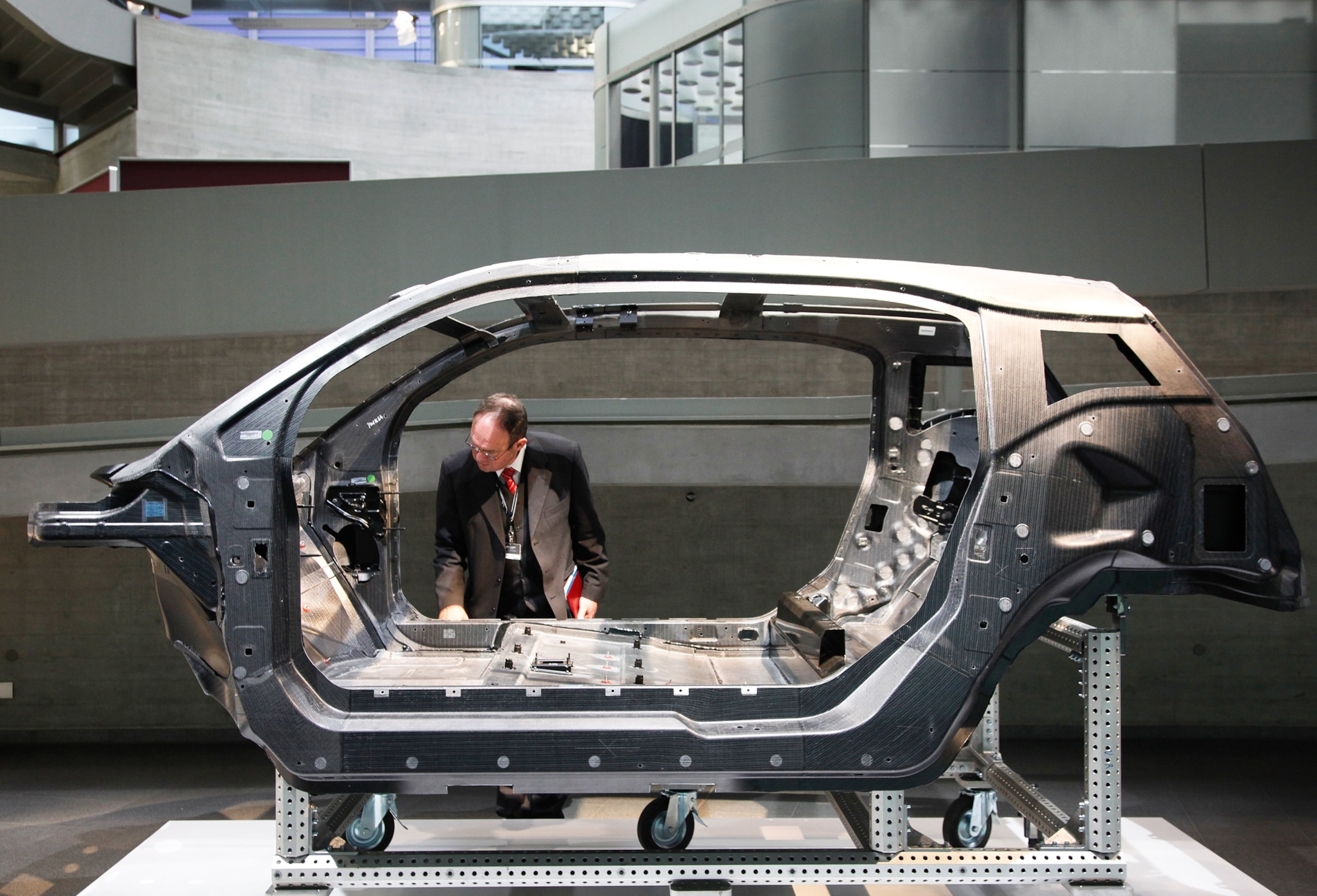 At a museum in a BMW auto plant in Leipzig, Germany, a carbon fiber car chassis is inspected by a visitor.