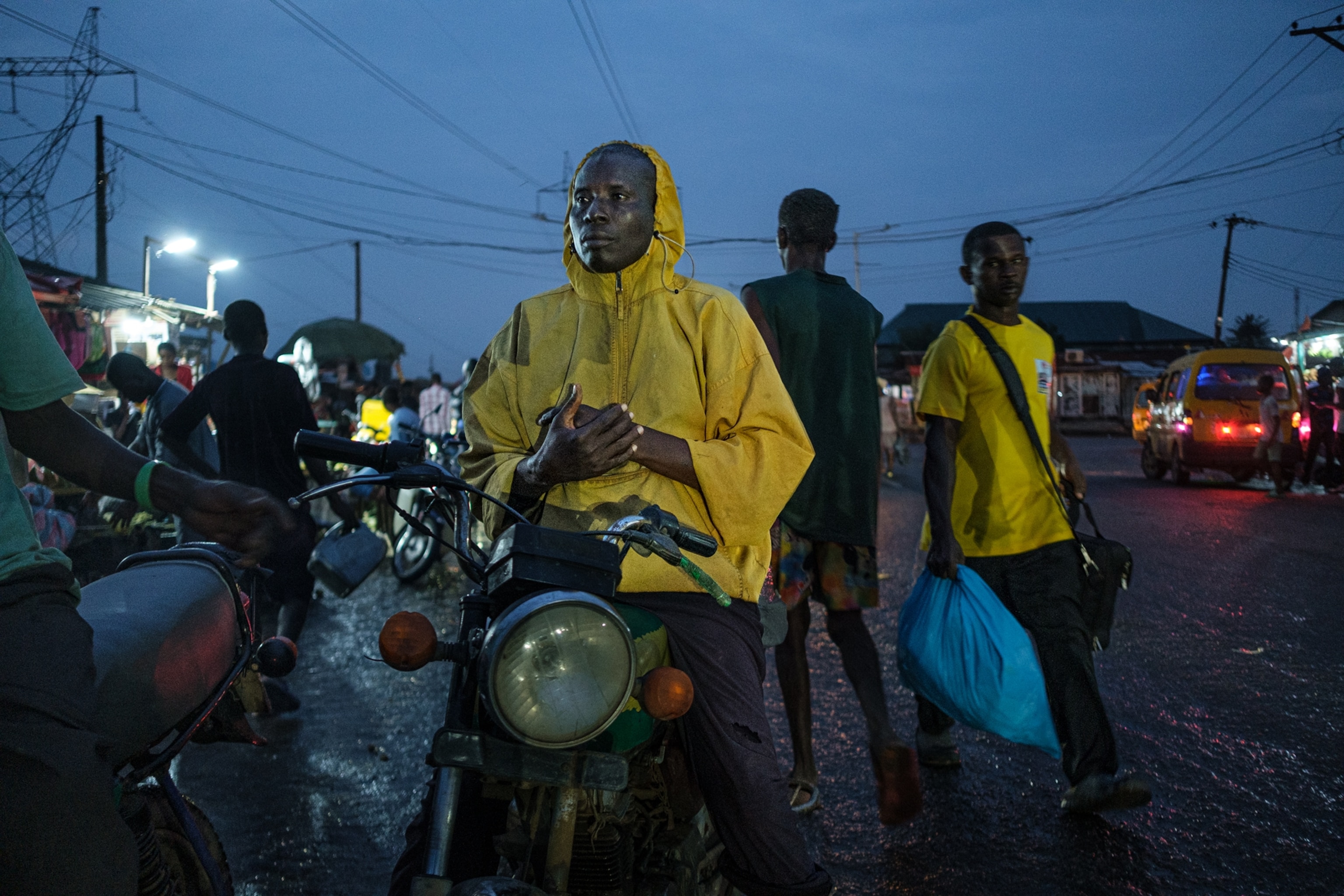 Young man in yellow raincoat on his motorcycle at dask.