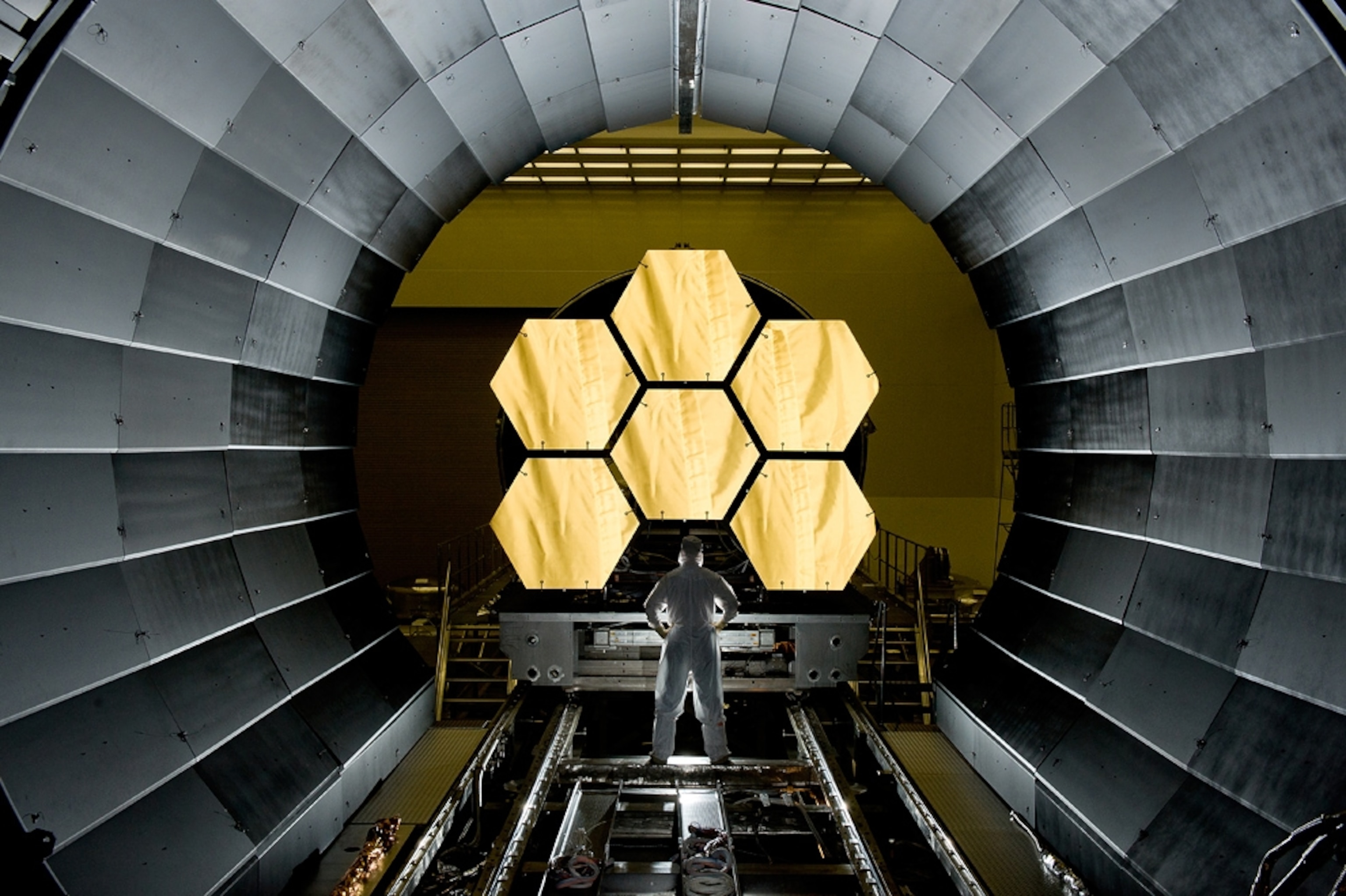 a man standing in front of mirror segments for the James Webb Space Telescope