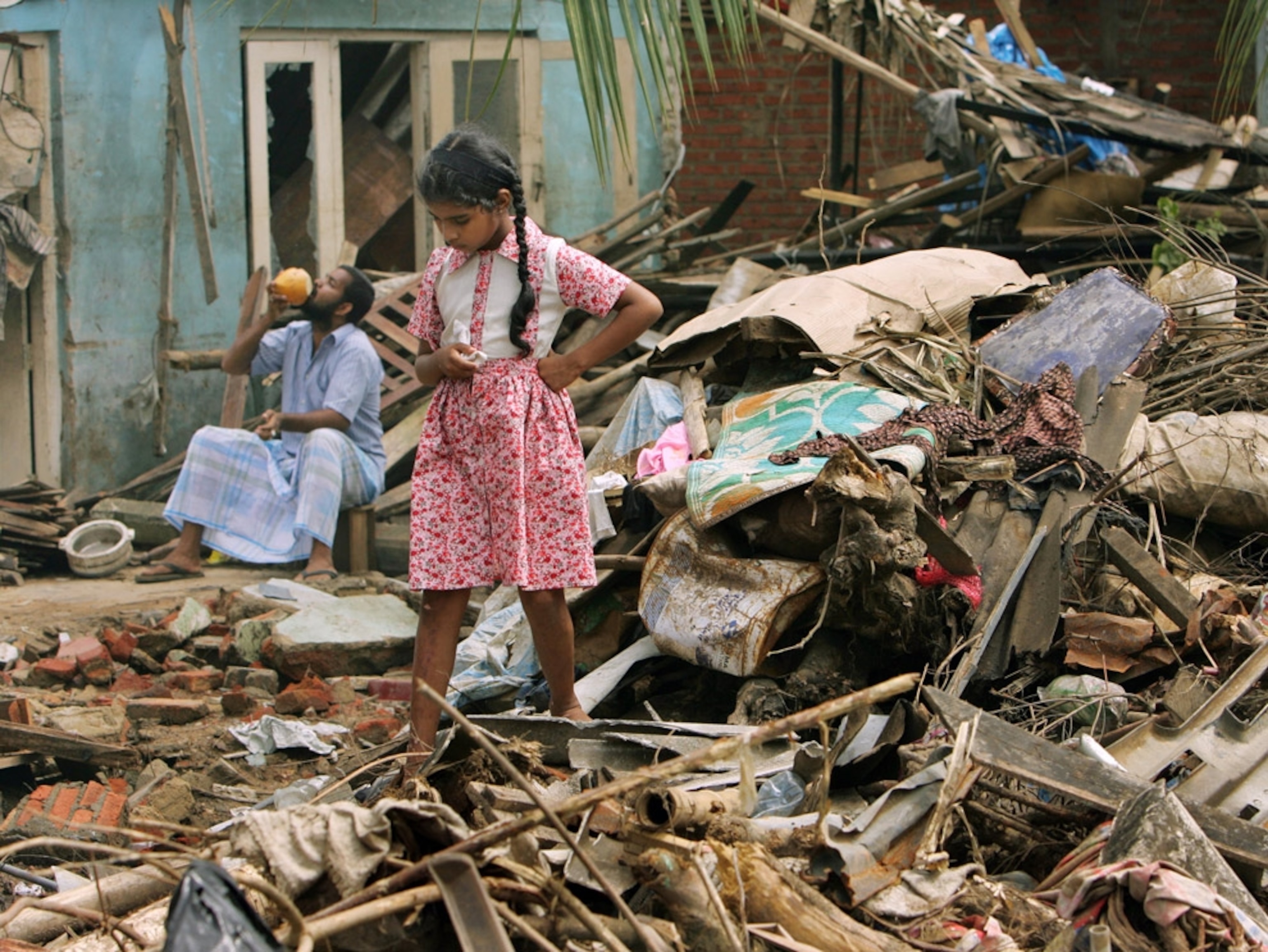 Clean up continues after Sri Lanka tsunami as little girl stands amid pile of rubble