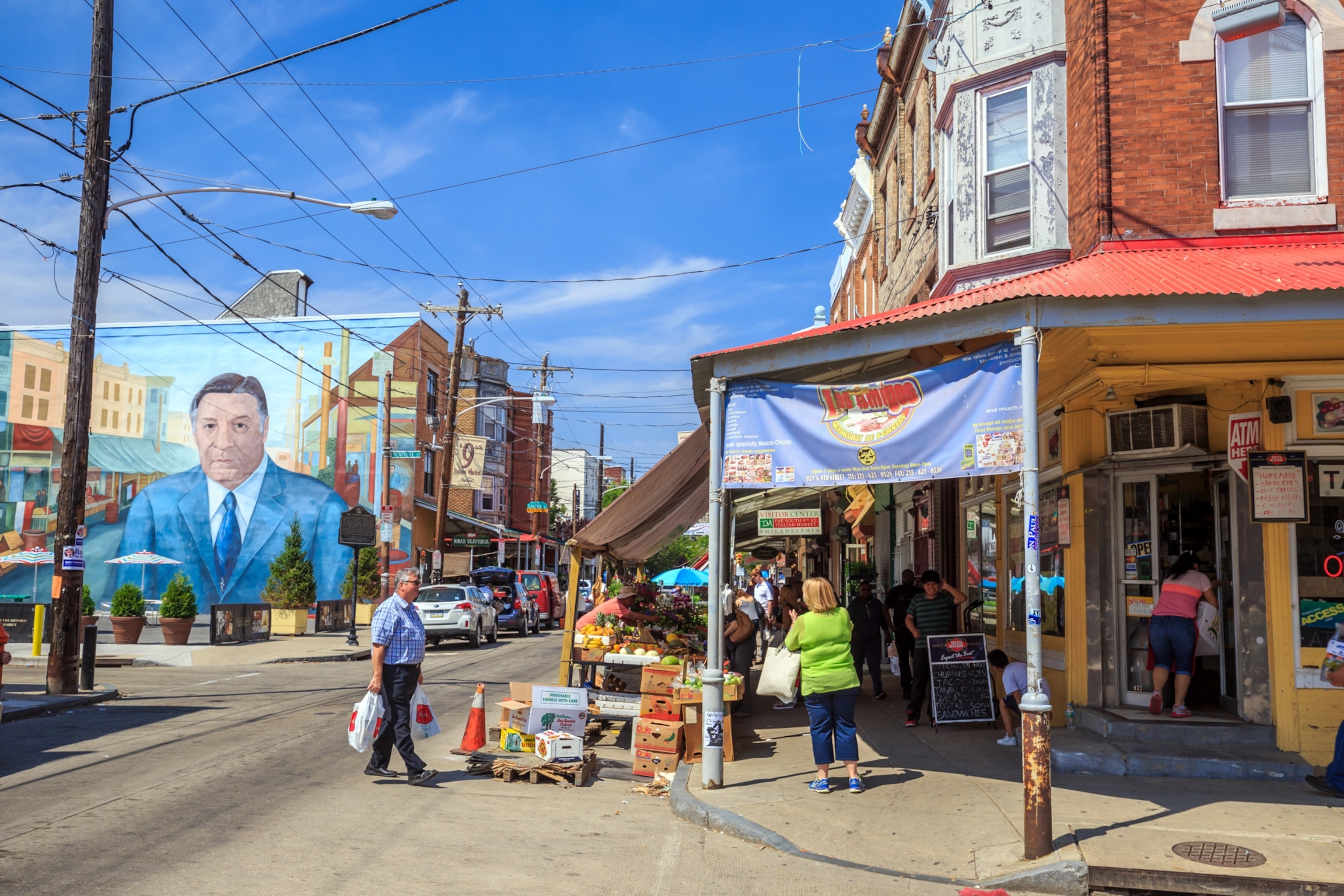 A person walks on the street by a market.