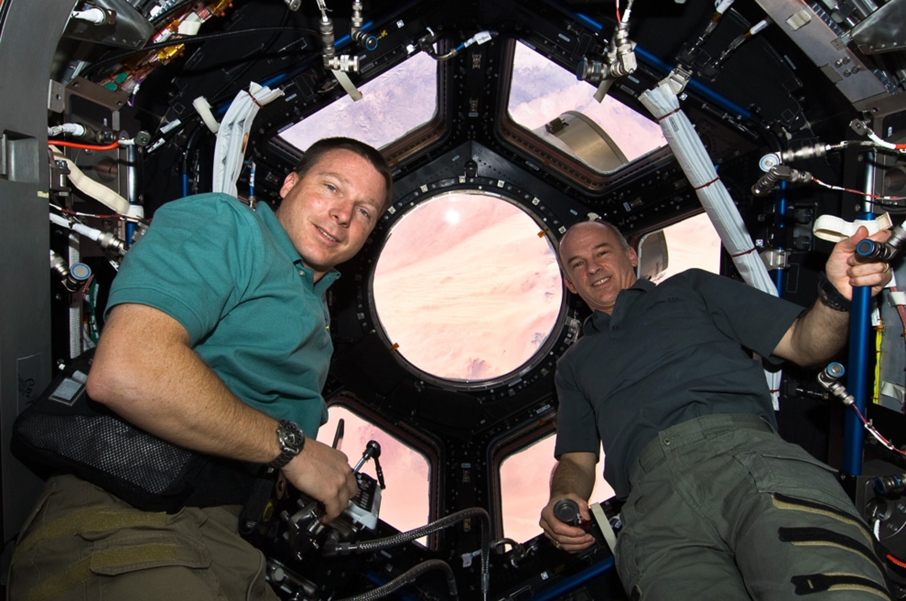 Astronauts pose inside the new cupola aboard the International Space Station in a new NASA picture