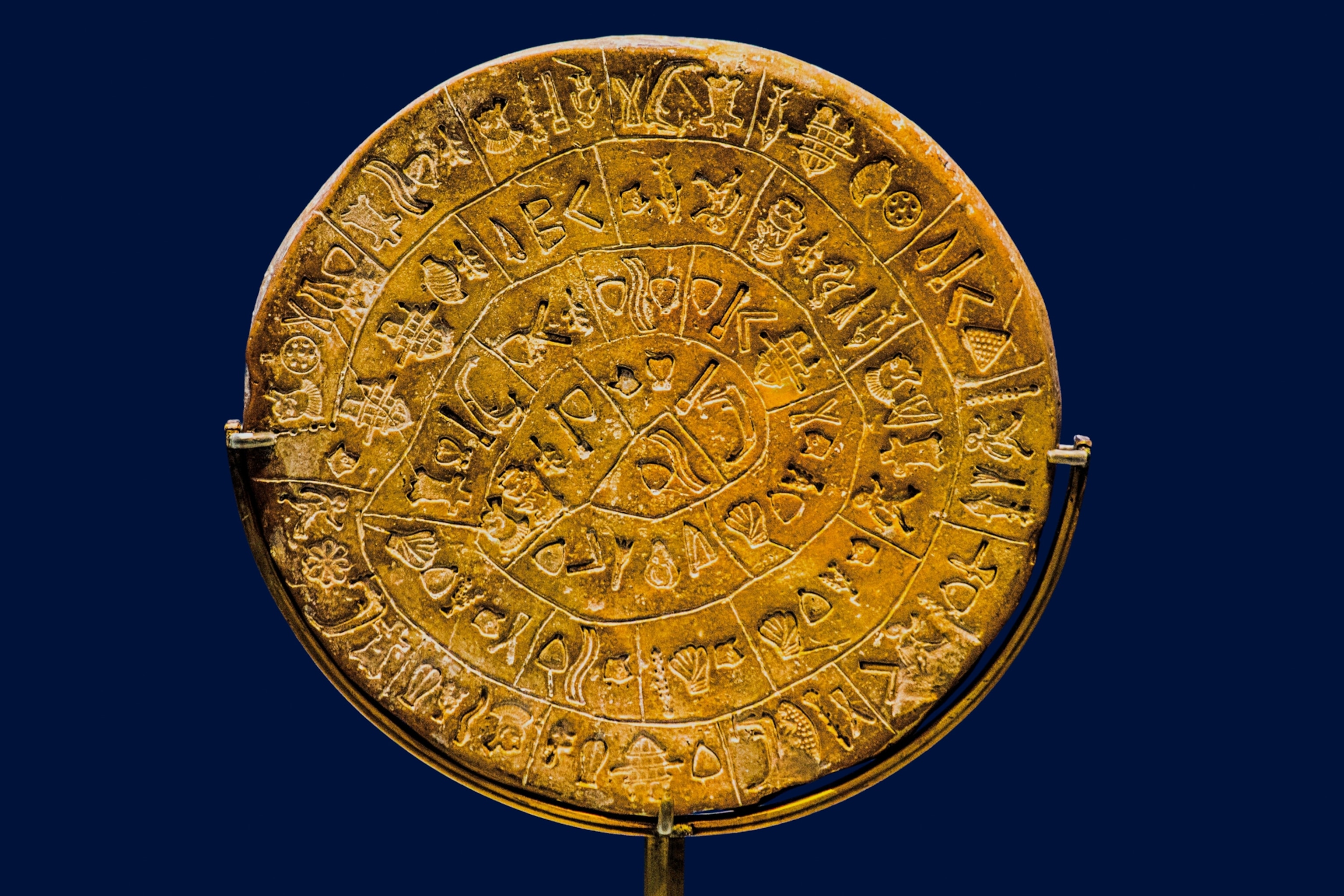 A circular yellow object has writing. The writing circles the face of the disk.