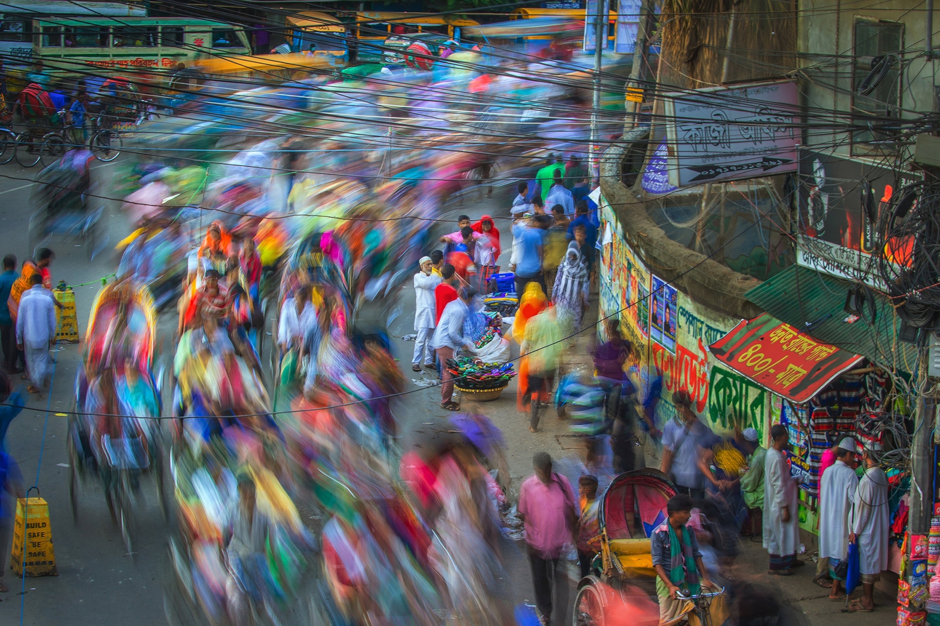 busy vendors and people rushing through the street at dusk, Bangladesh