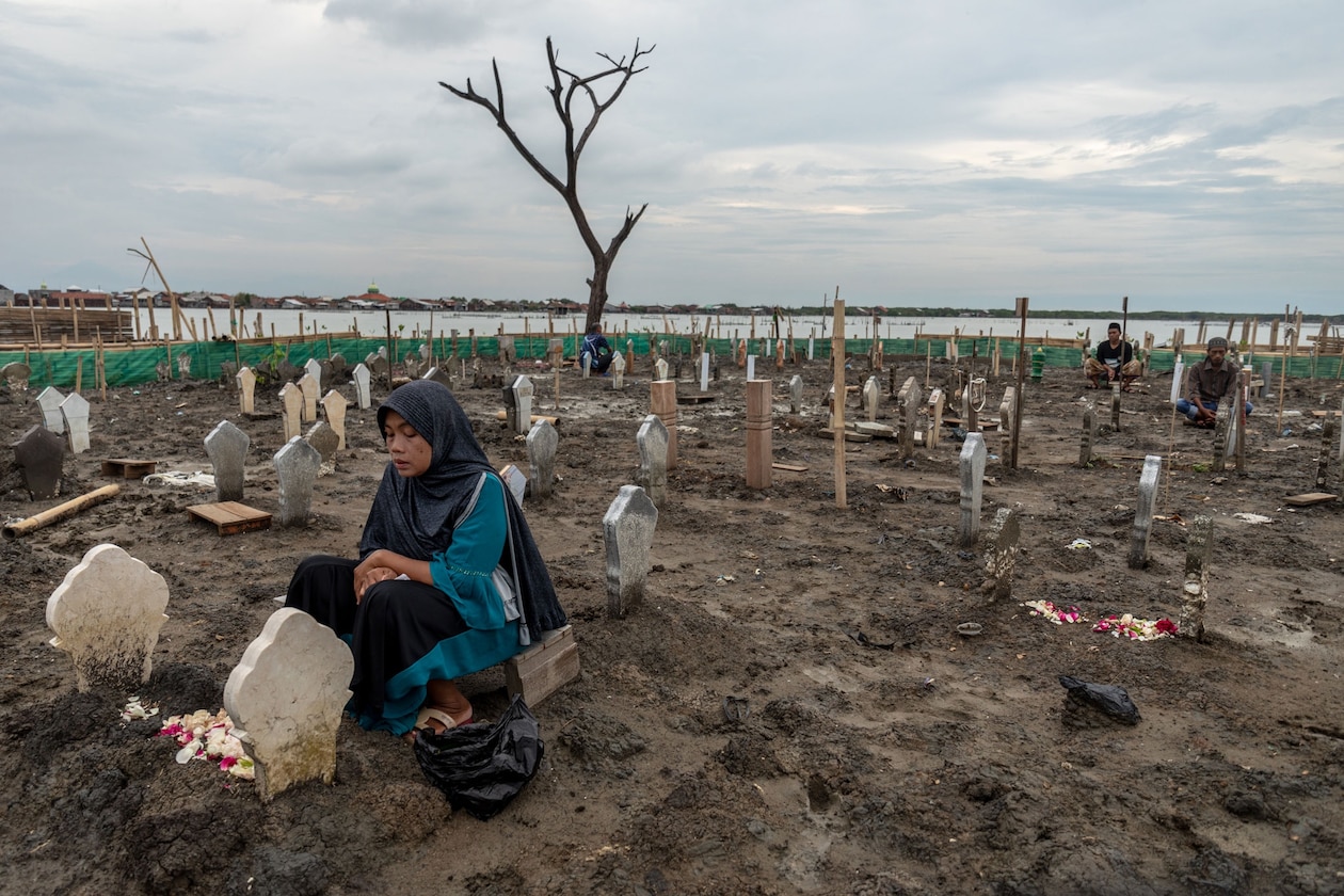 Woman prays in cemetery.