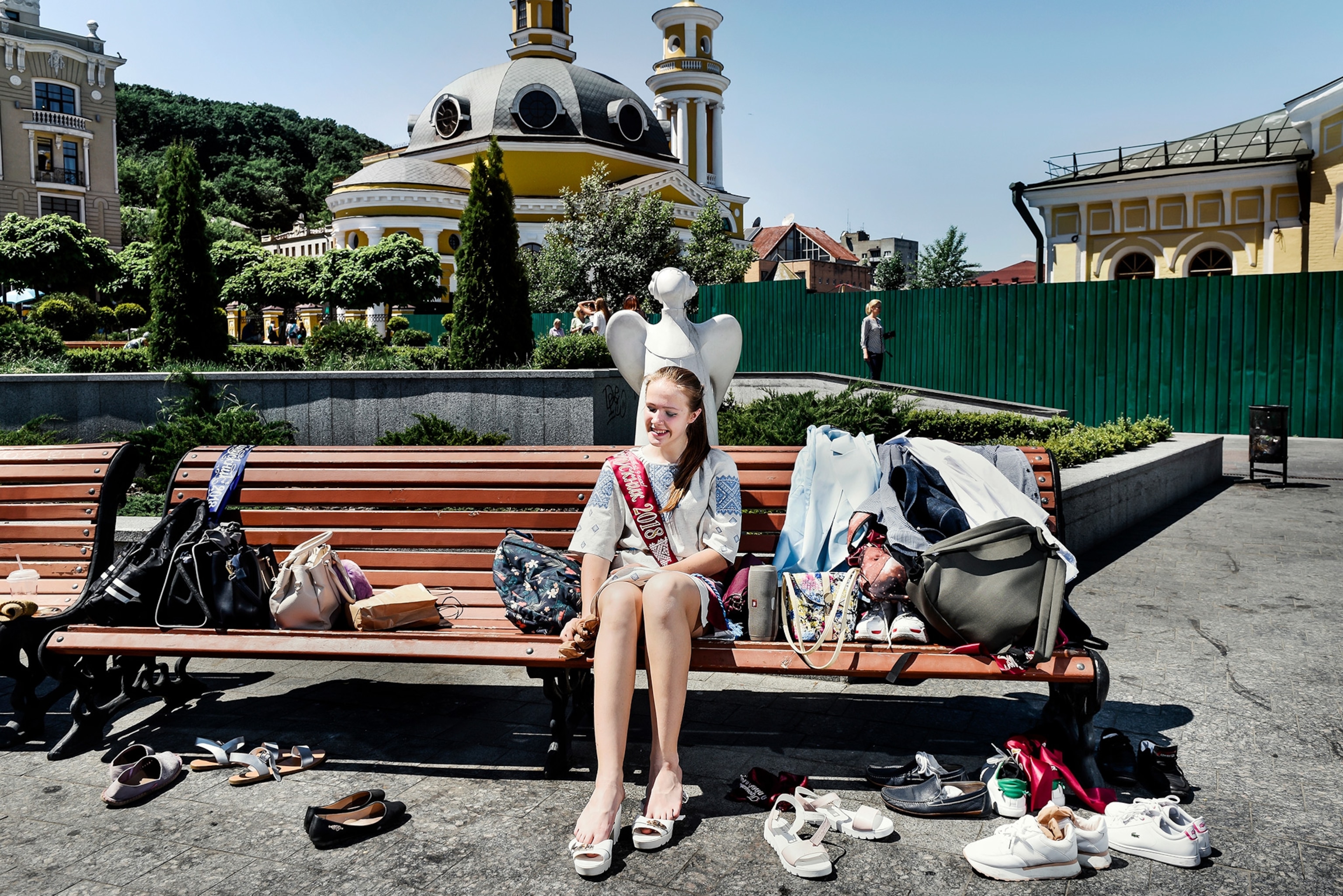 a girls sitting by a fountaina after the last day of school in Kiev, Ukraine