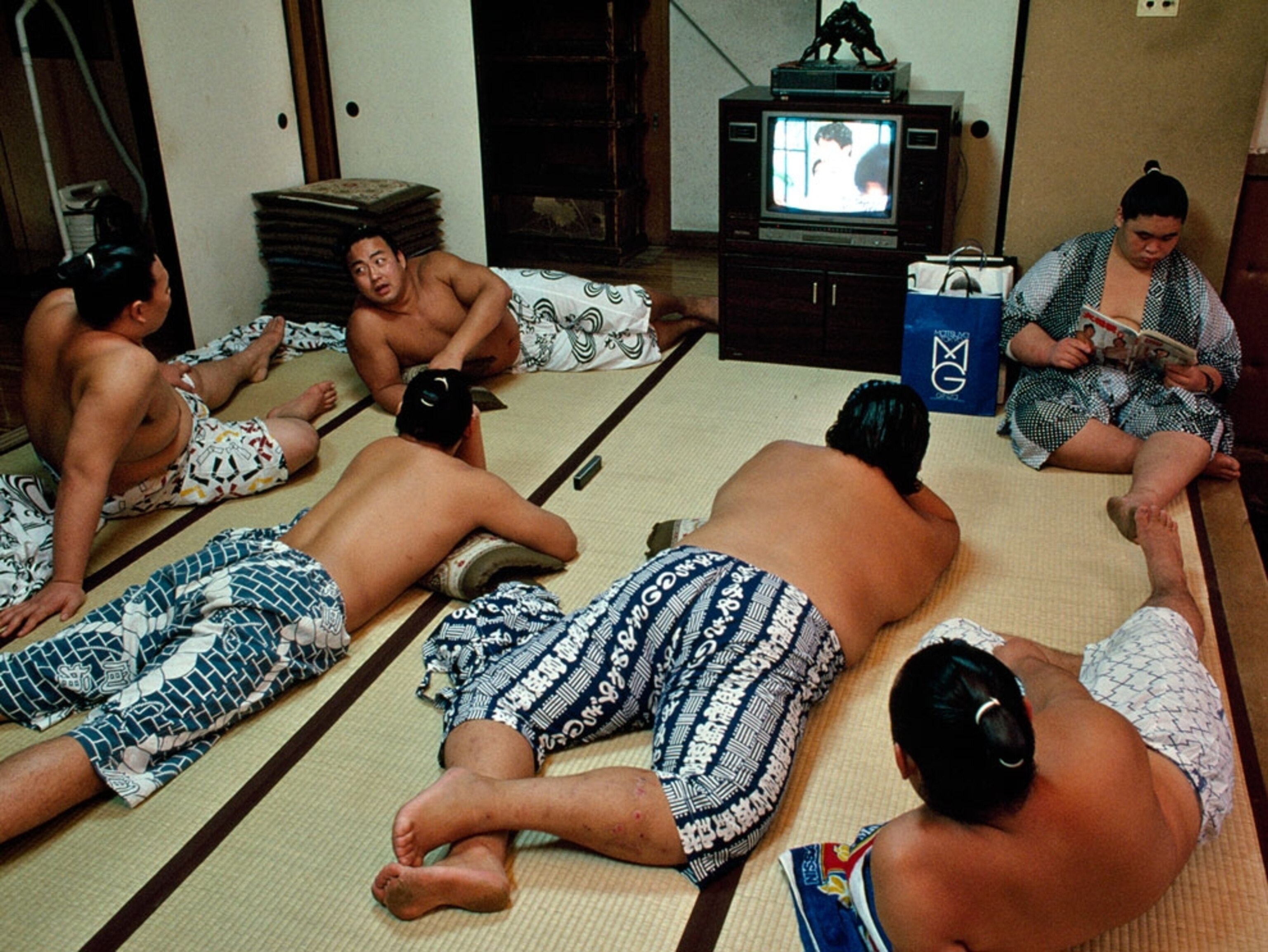 Men lying on floor watching TV