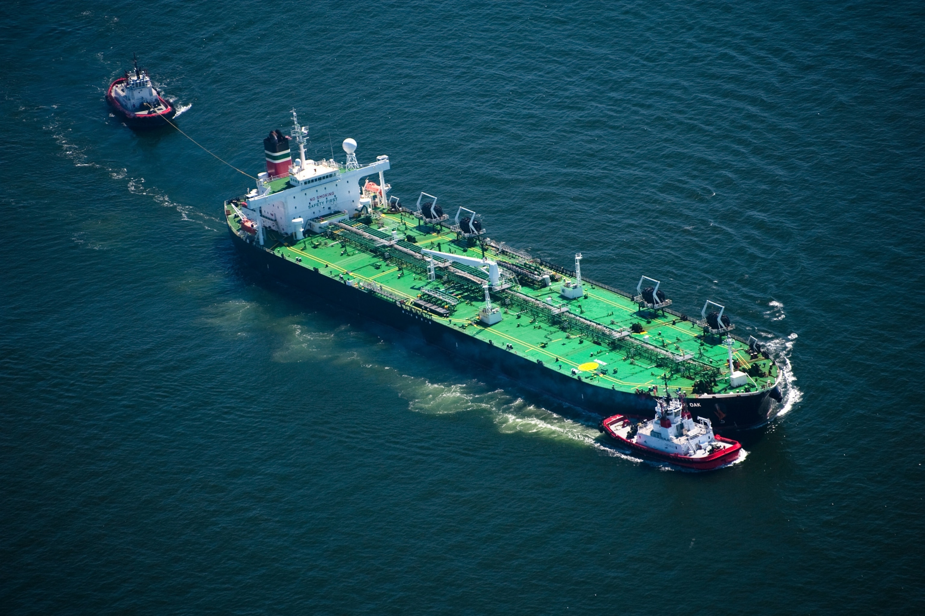 an oil tanker and tug boats.