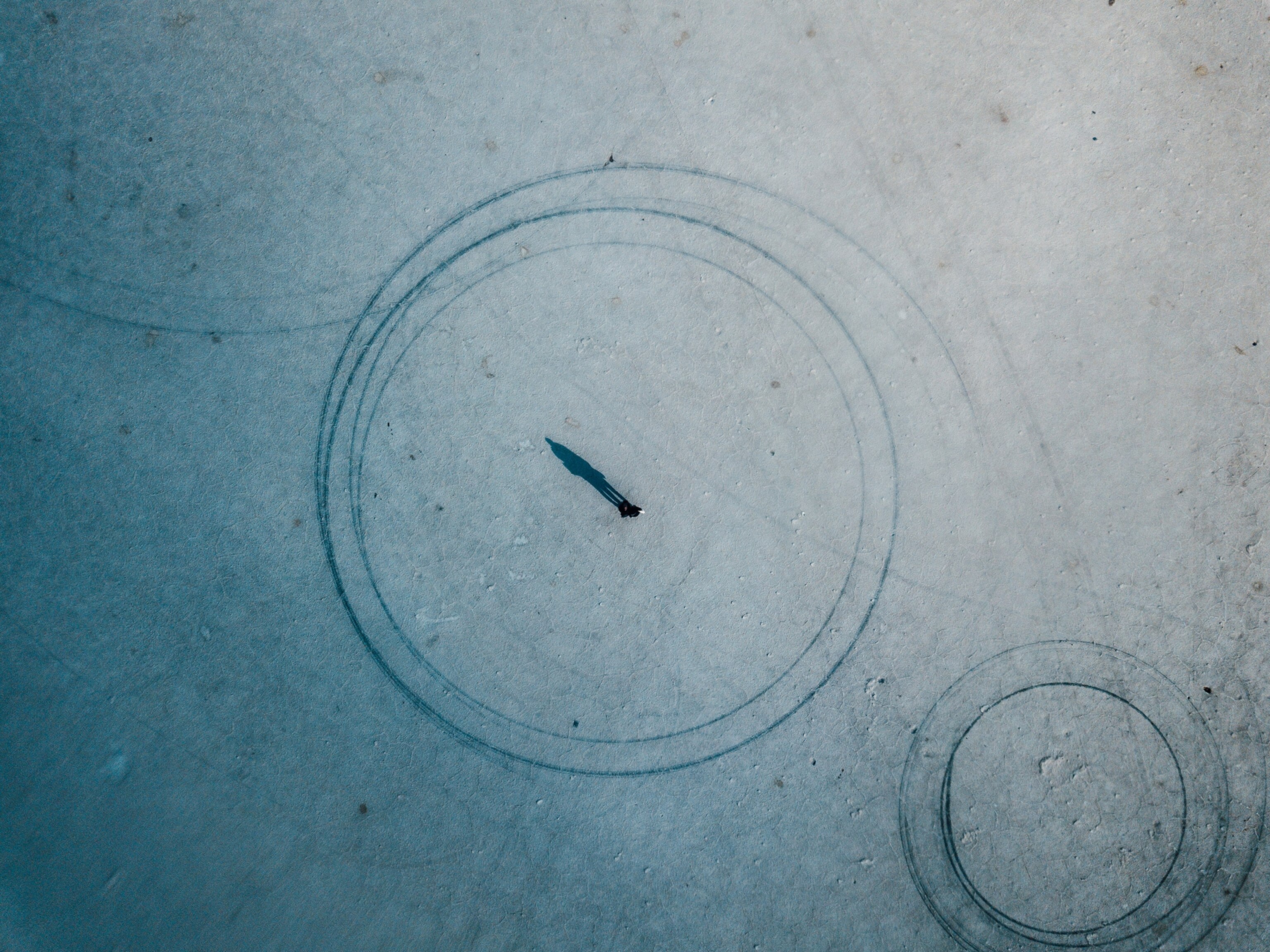 Aerial picture of a person standing on salt flats of Salar de Uyuni, Bolivia