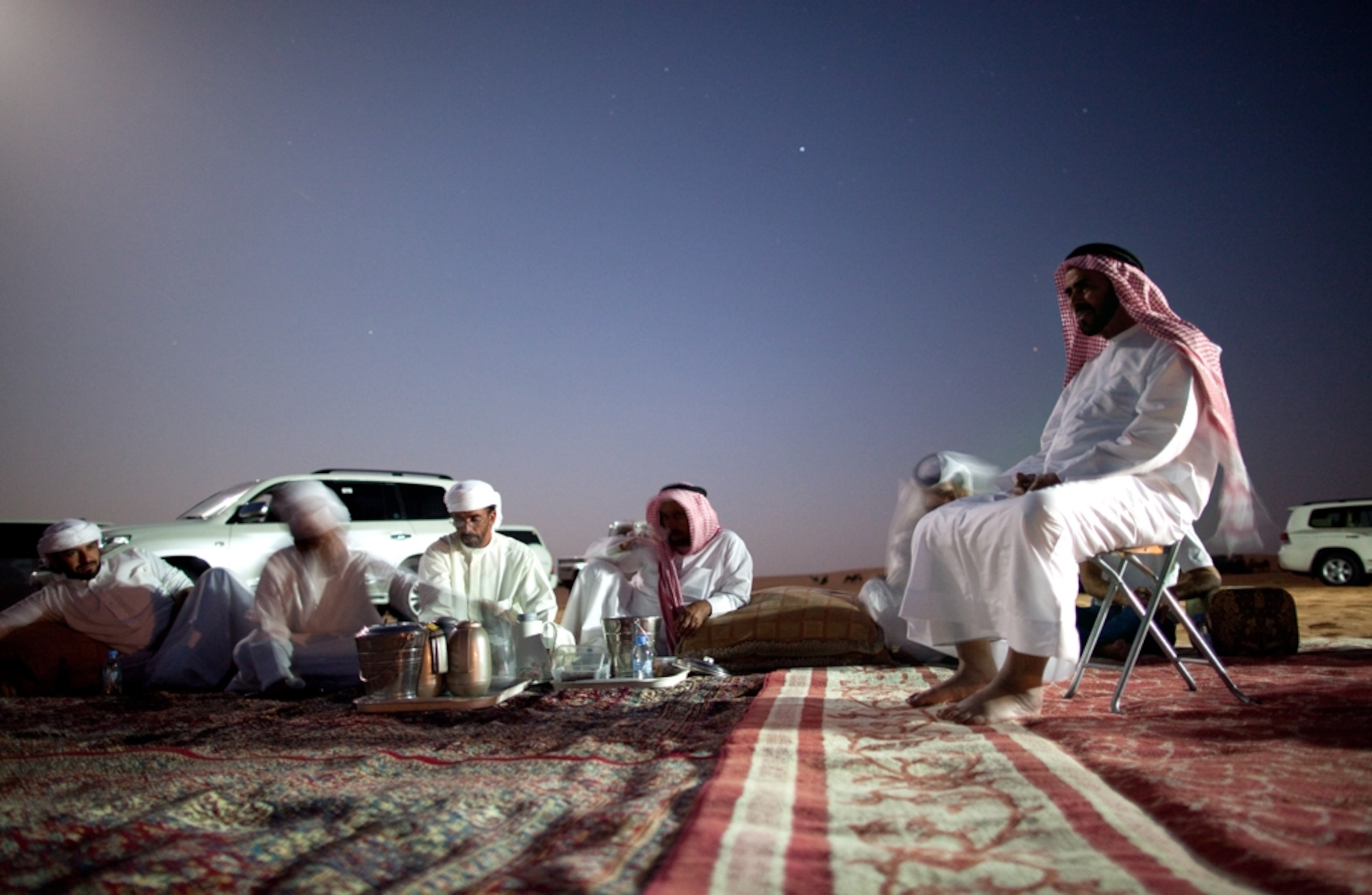 Bedouin eat dinner on rug outside