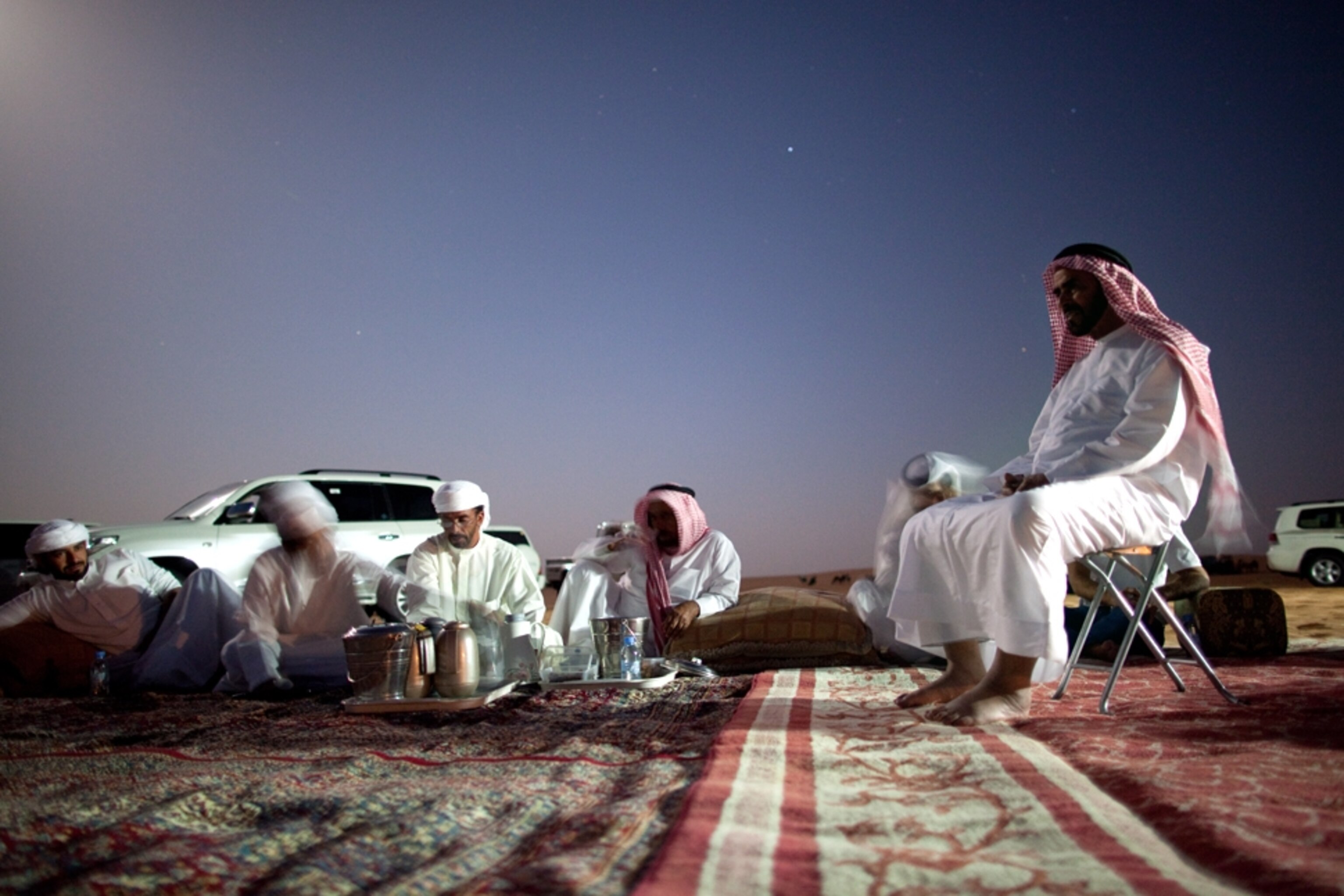 Bedouin eat dinner on rug outside