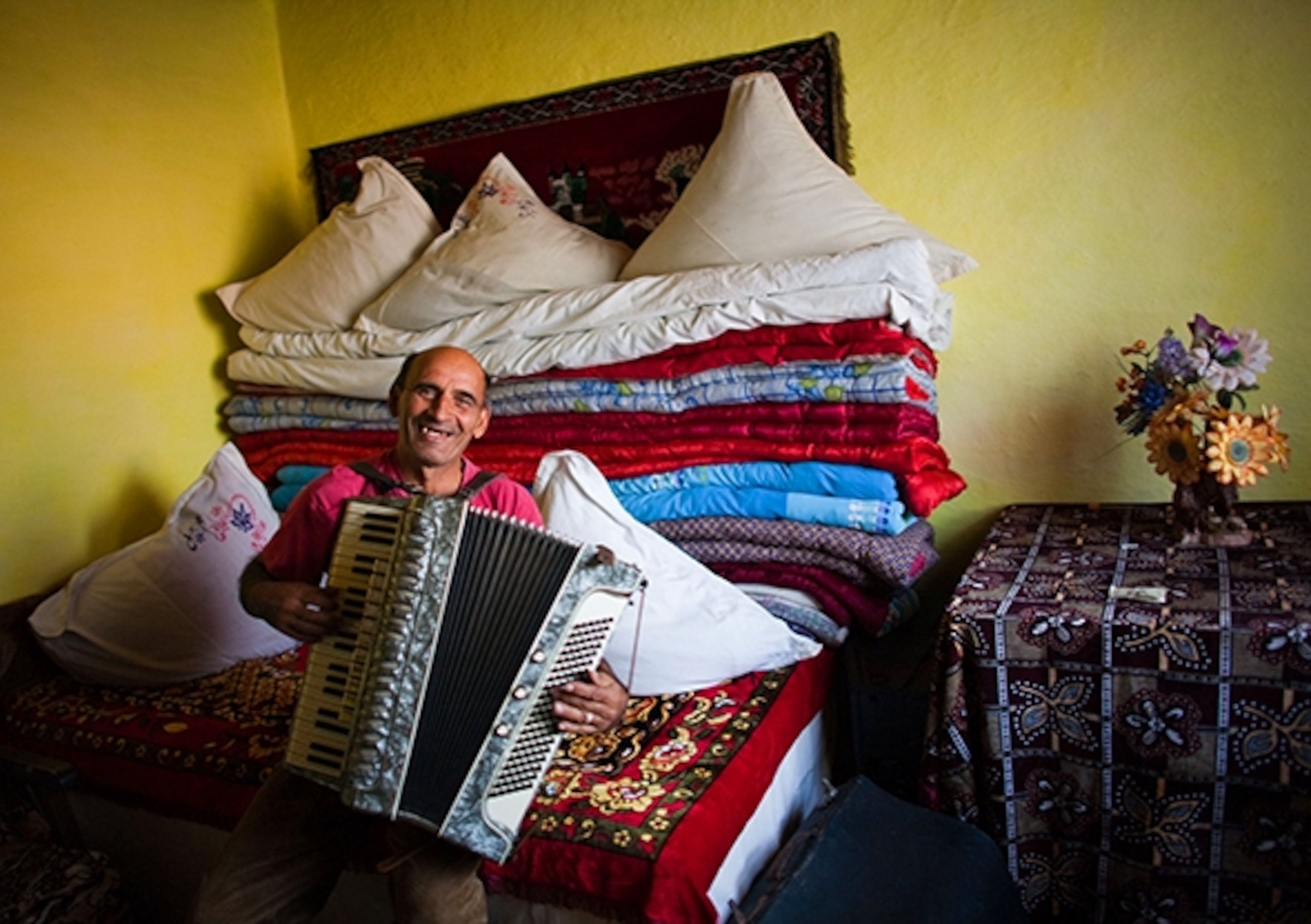 Music making is as natural as breathing in Zece Prăjini, where a villager plays accordion in a bedroom. (Photograph by Bogdan Croitoru)
