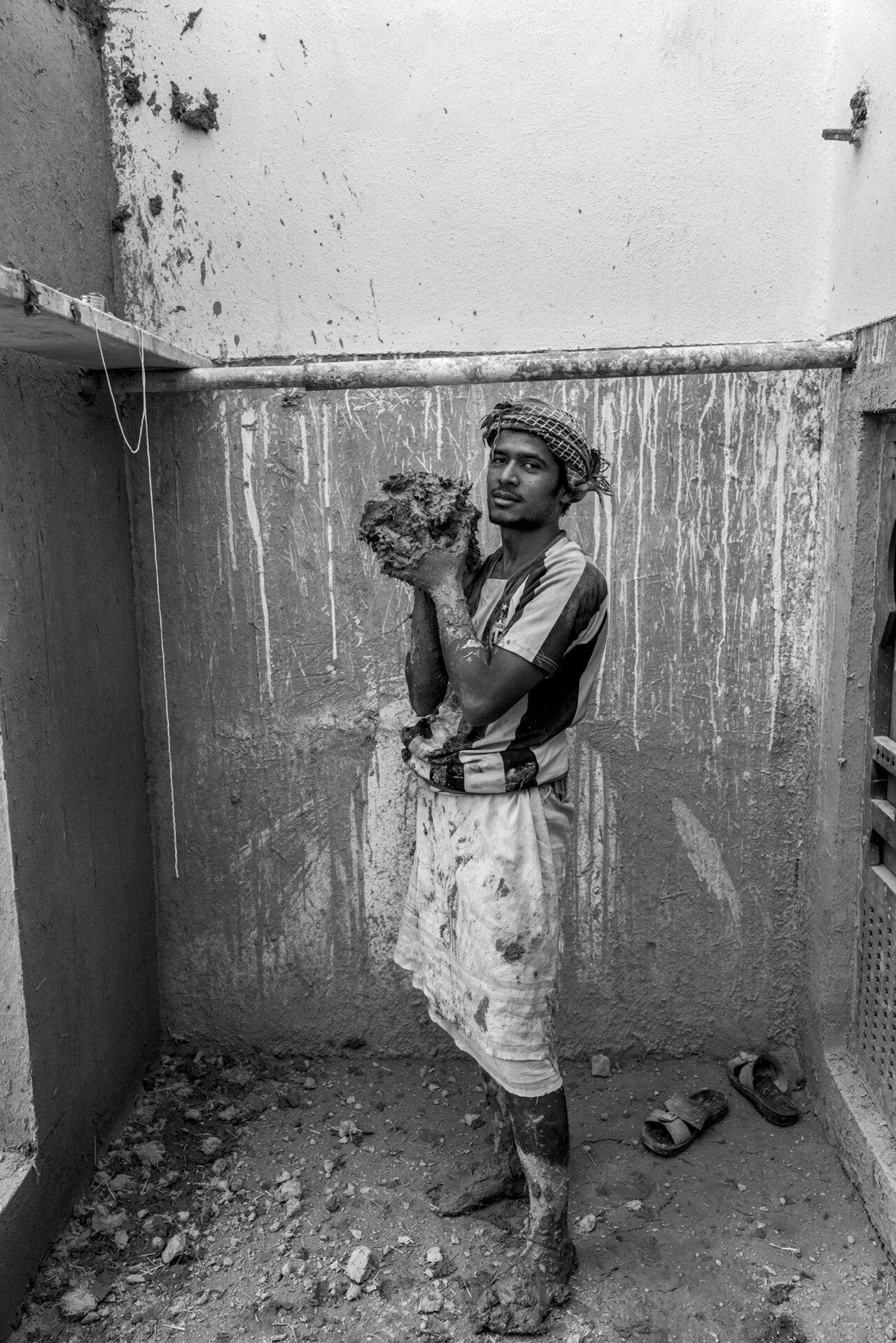 Picture of young man holding a lump of mud.