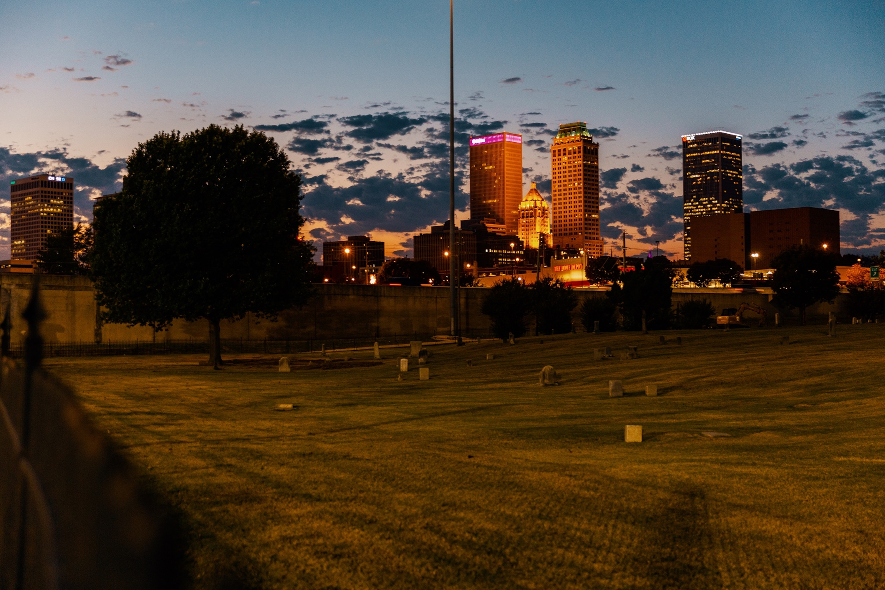 Tulsa city skyline seen at night behind cematary