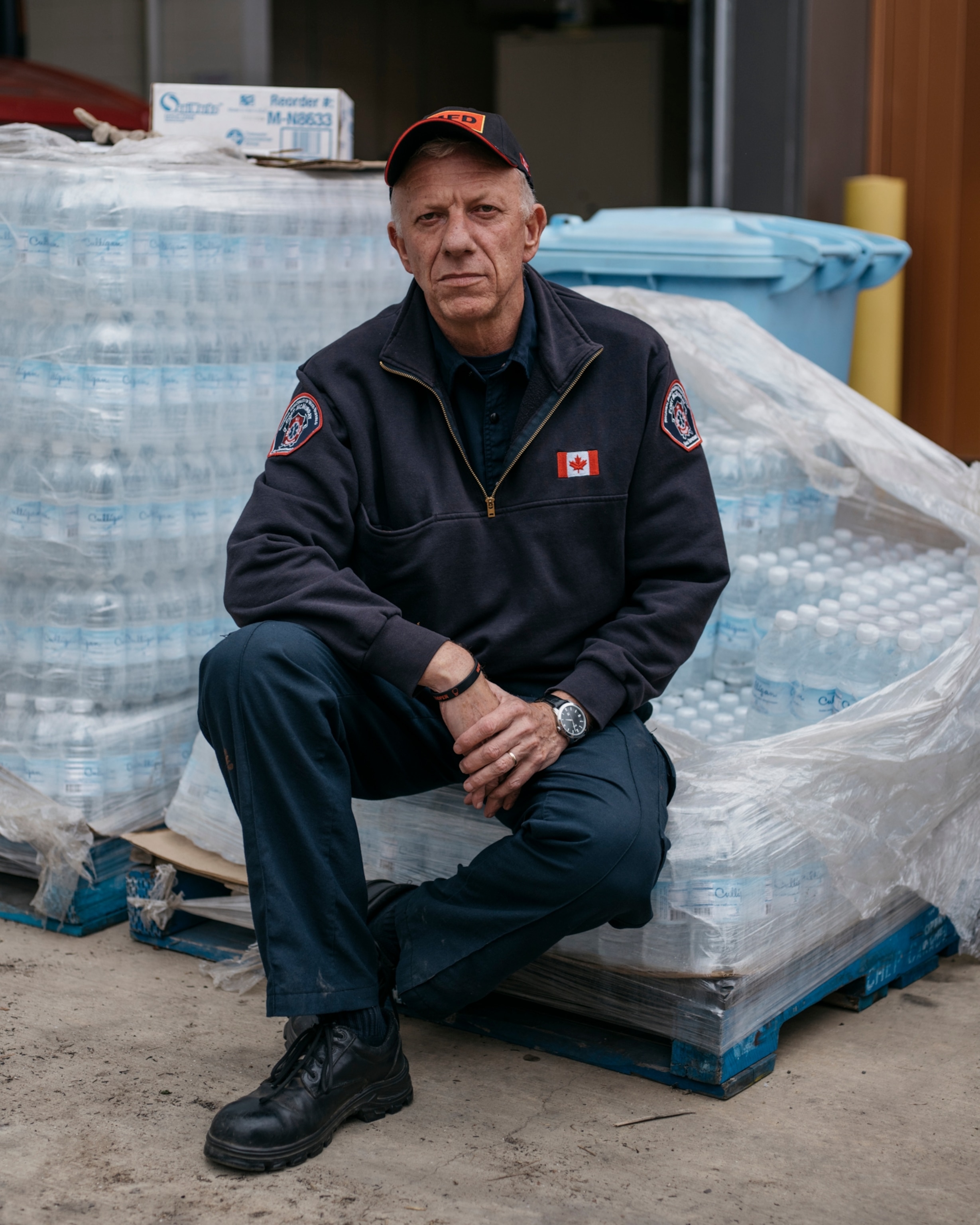 a man sitting on cases of bottled water