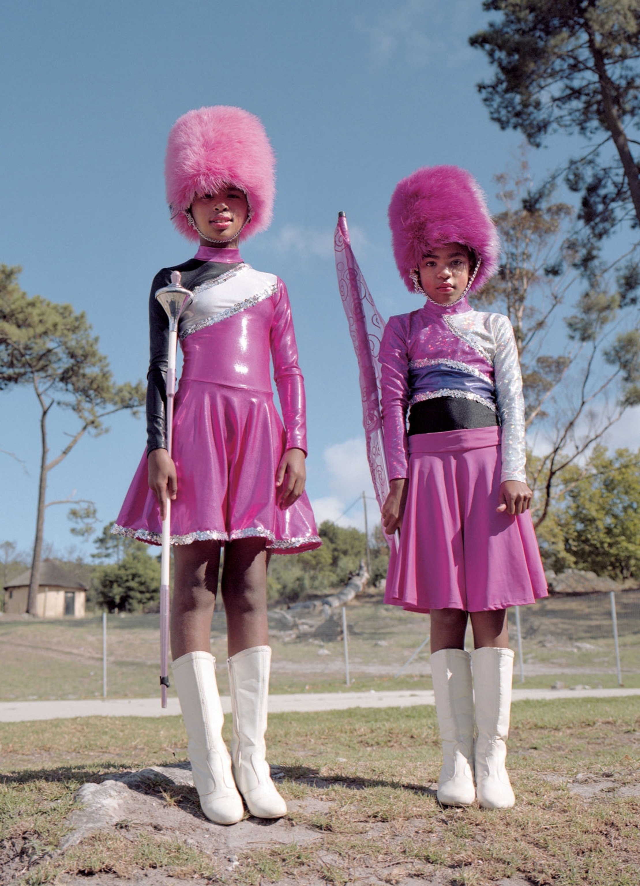 two young women in pink uniforms outside