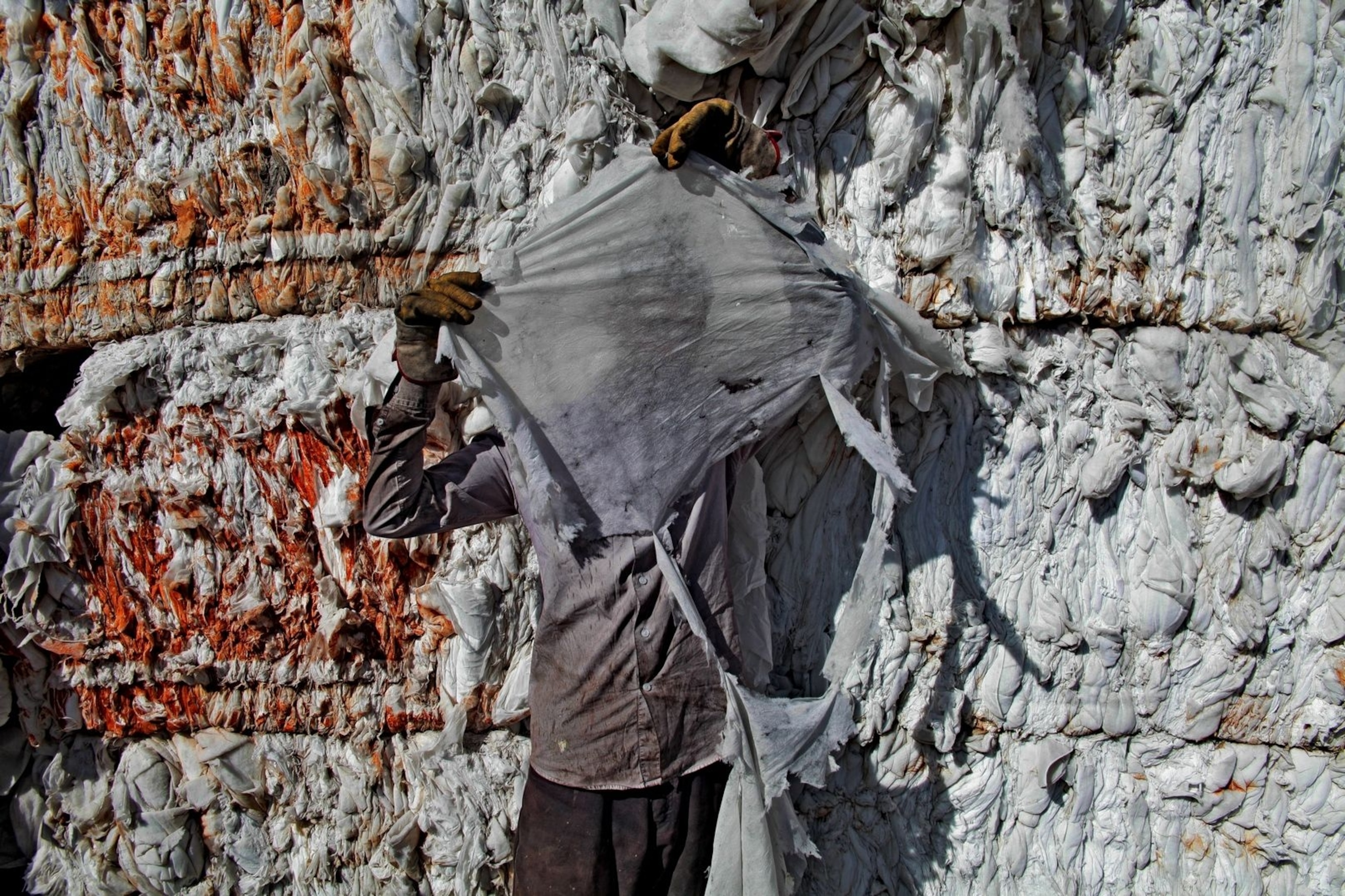 A worker at Reggio Maceri shields his face with a scrap of trash.