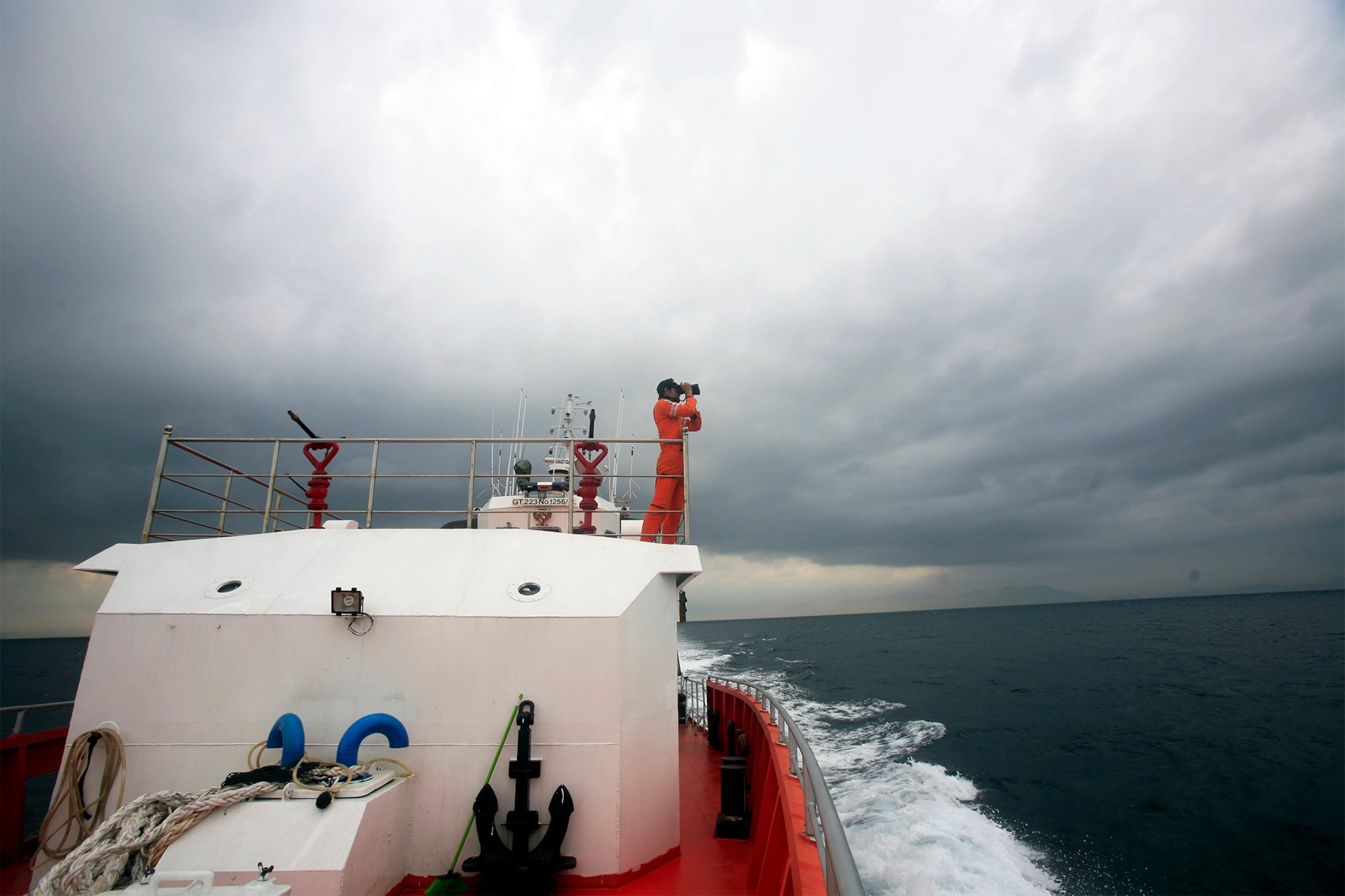 a person looking out from a rescue ship for the missing Malaysian plane.