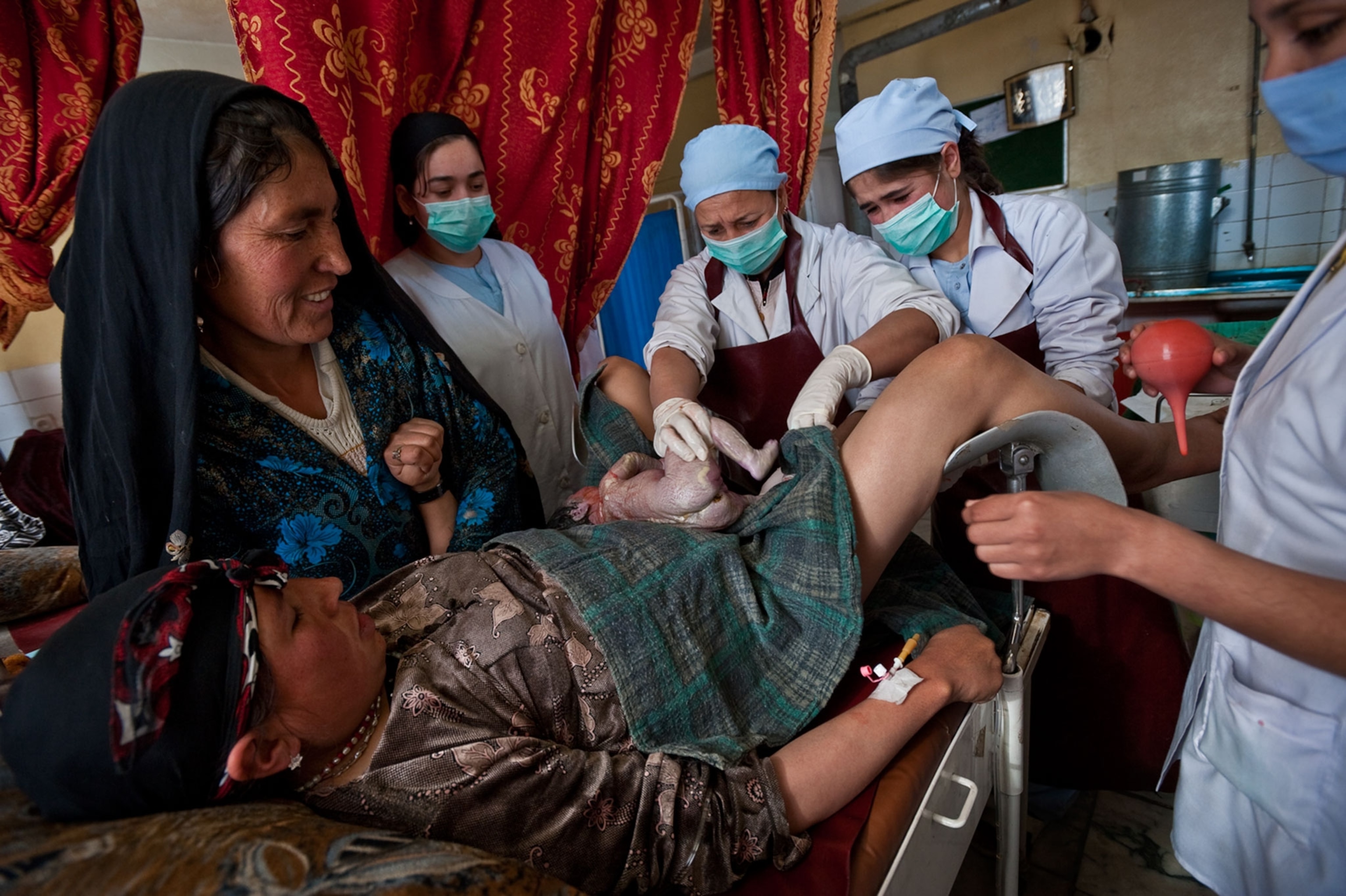 nurses helping woman give birth to twins