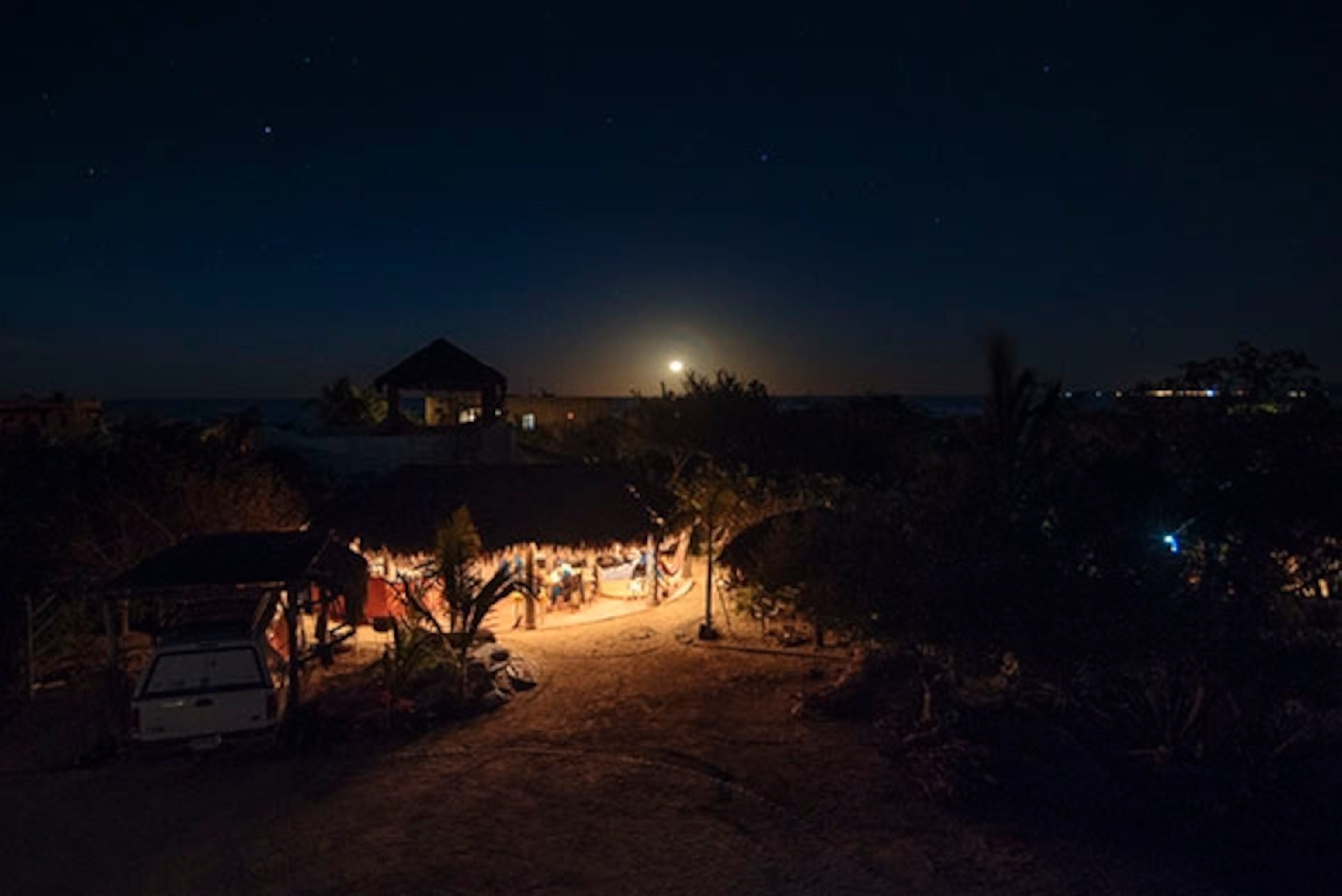The main palapa of Chris's compound lit by stars, and the light of a full moon; Photograph by Max Lowe