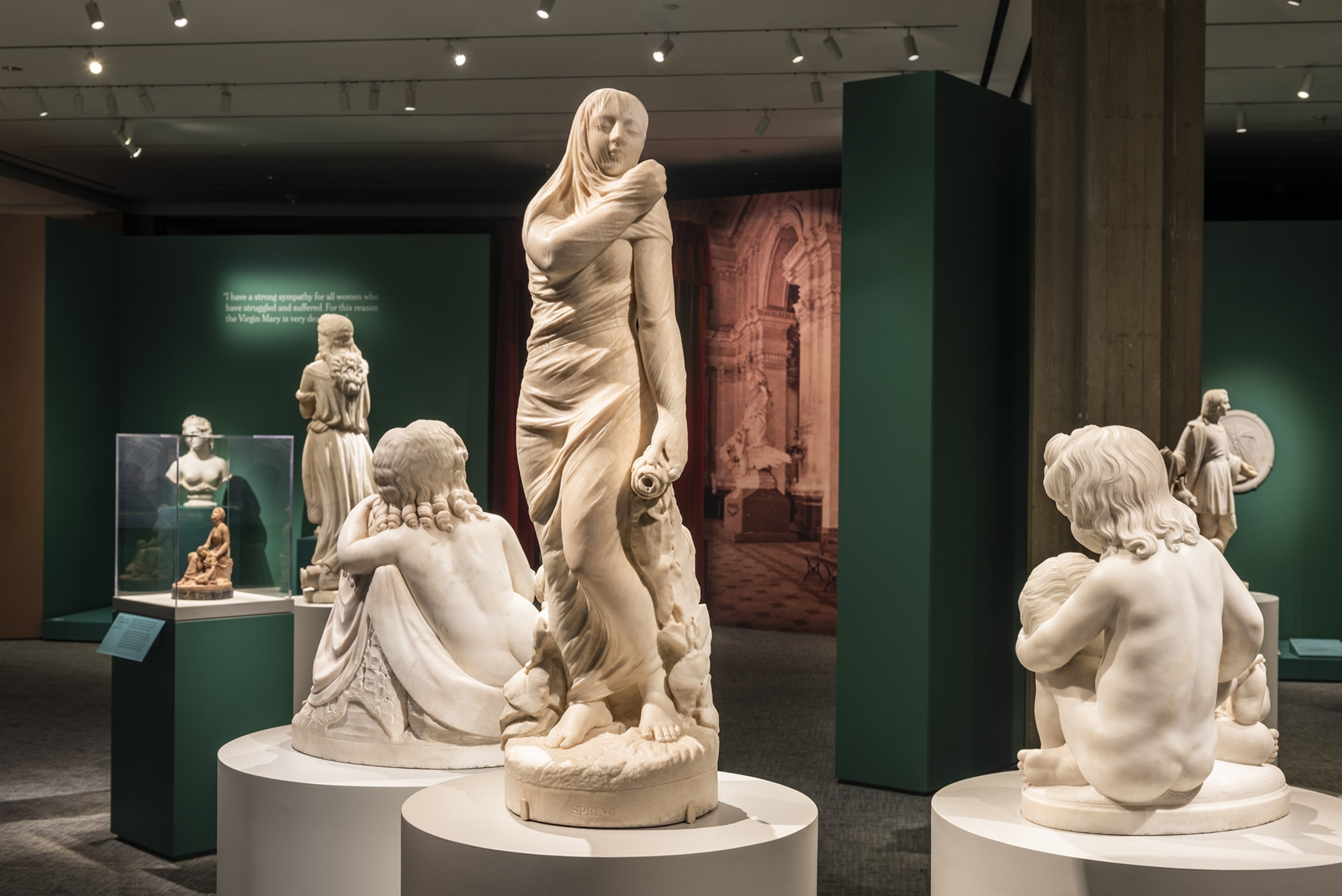 A collection of white marble statues on display in a museum