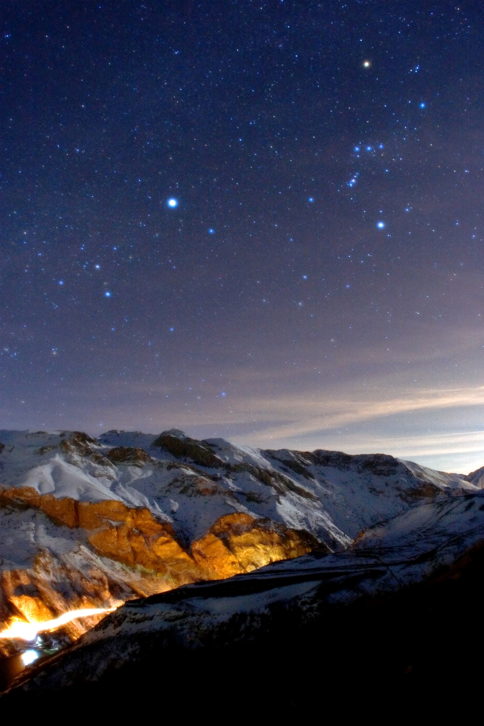 Snow-capped mountains under a starry night sky