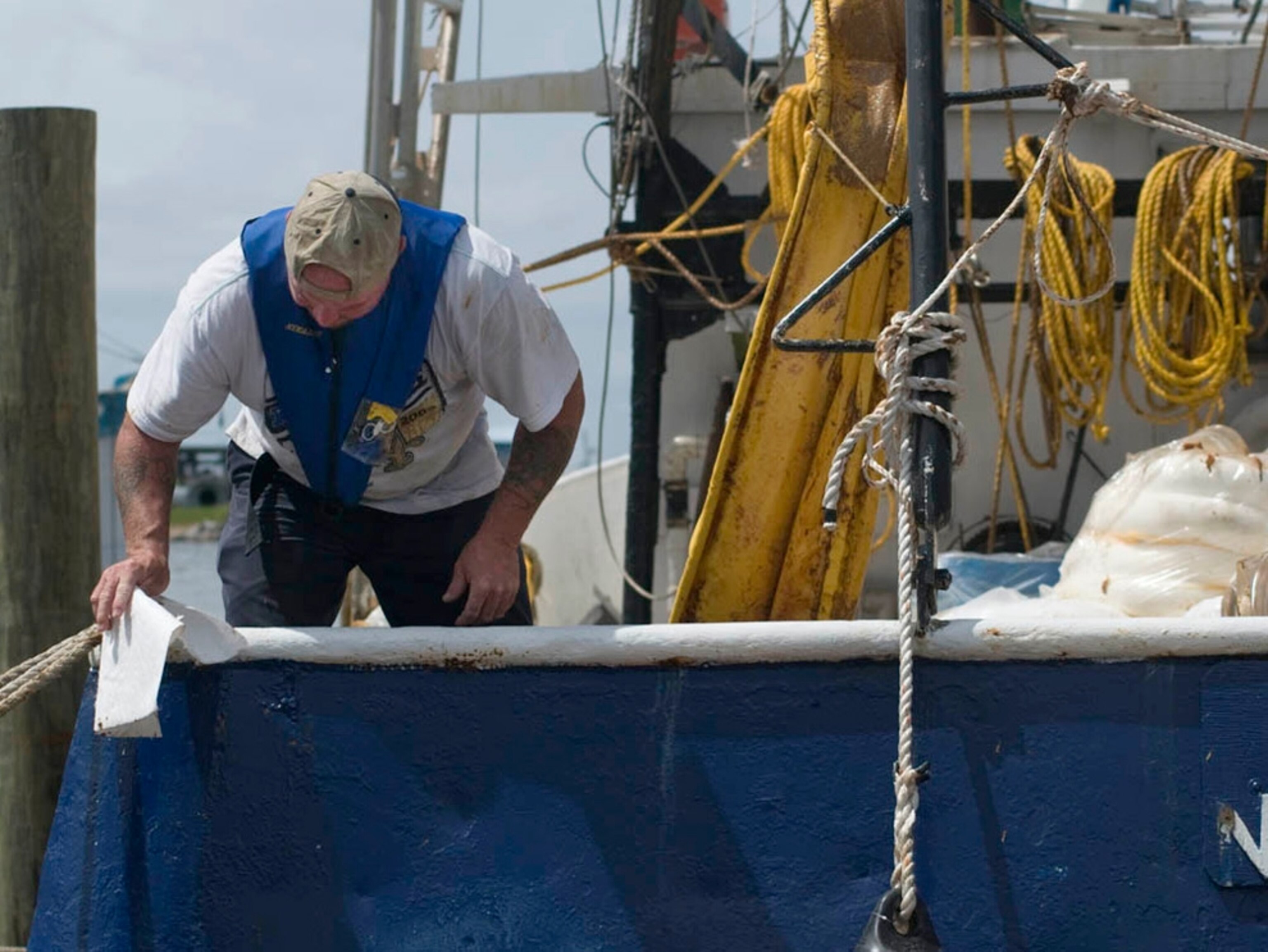 a boat captain cleaning oil from his ship in Port Fourchon, Louisiana.