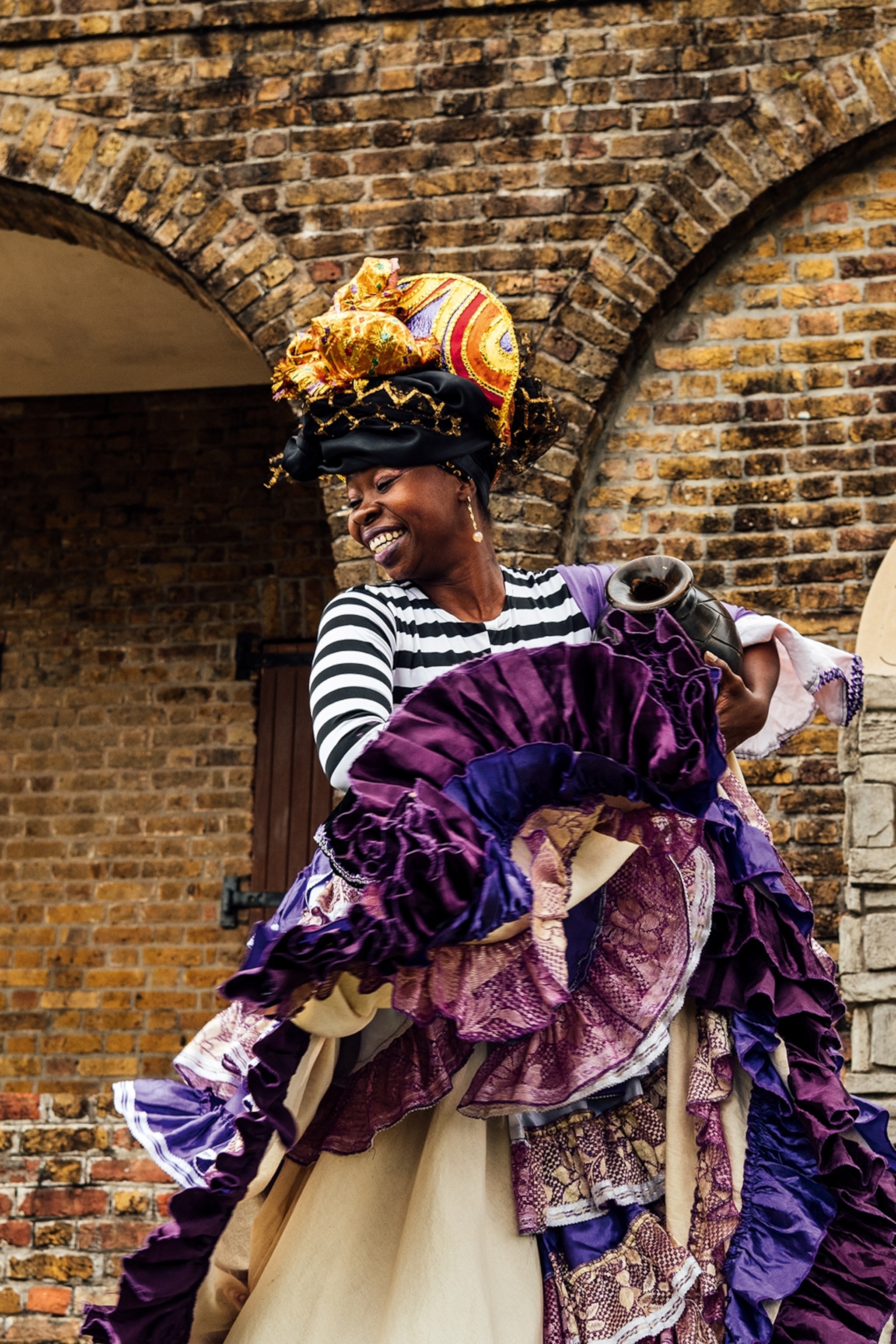 A woman wearing a head turban and frilly skirts dancing.