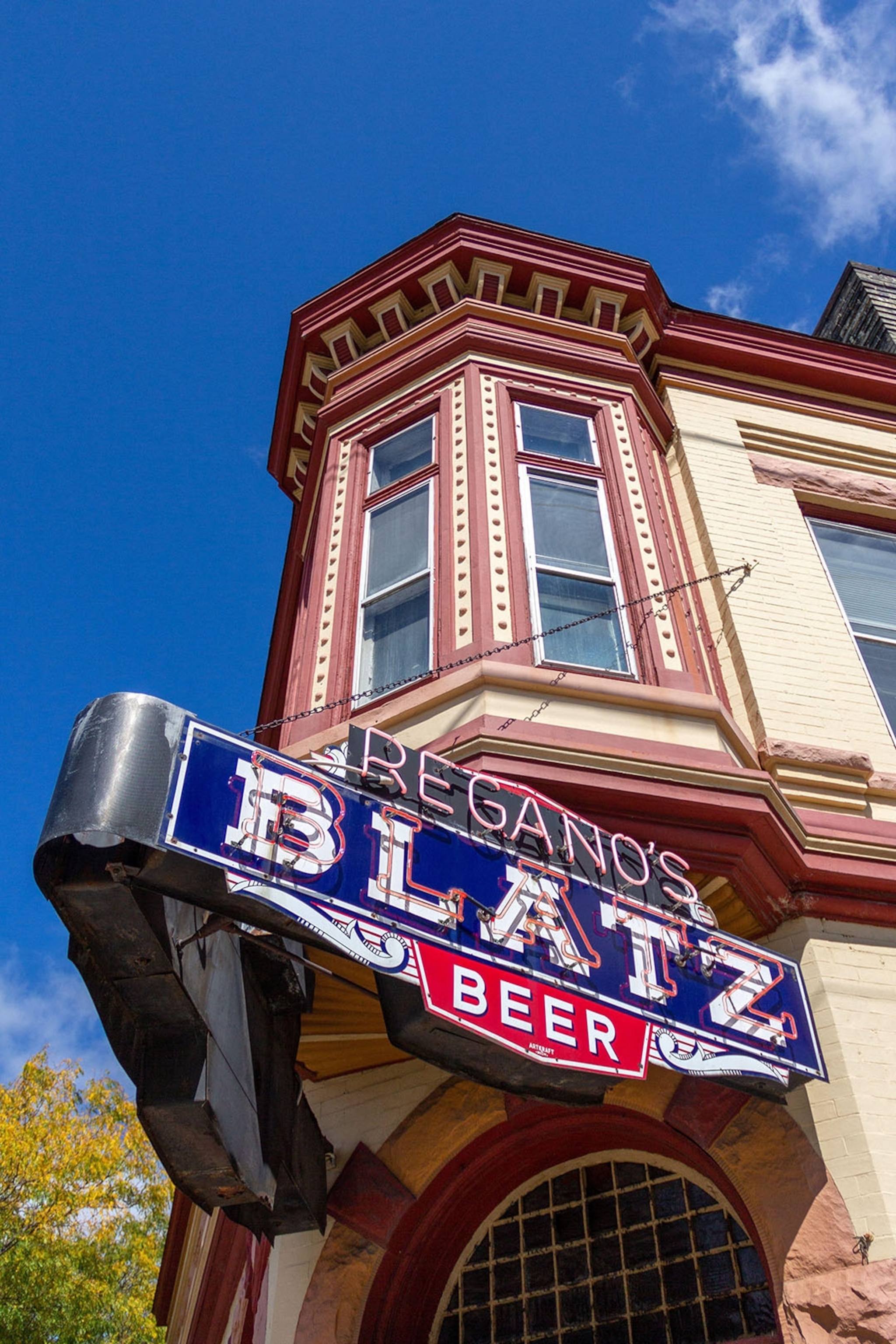 An upwards angled shot of a brewery sign attached to a high building.
