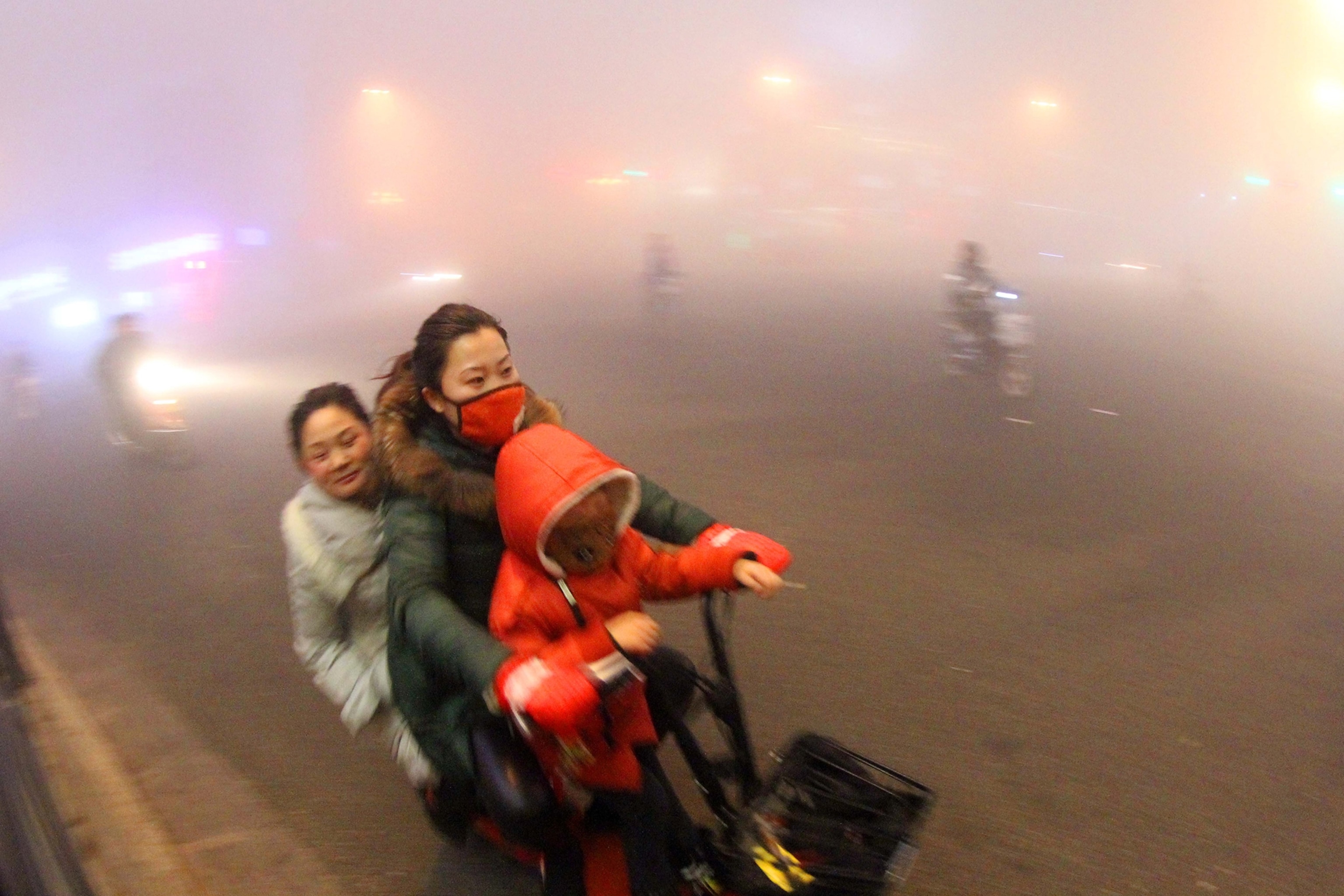 Cyclists ride on a road in heavy smog in Ganyu county, Lianyungang city,