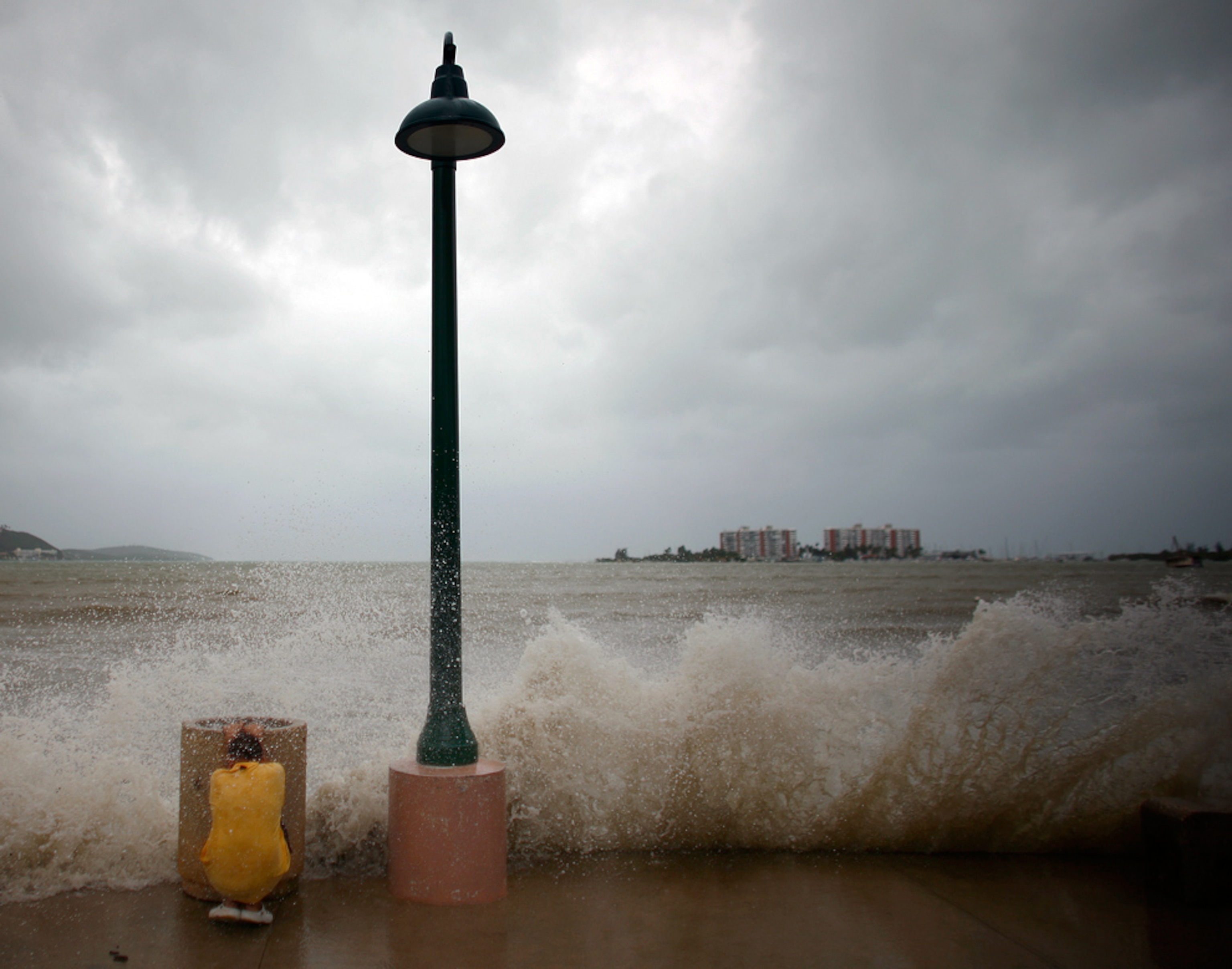 A boy takes cover from a wave caused by Hurricane Earl in Fajardo, Puerto Rico.