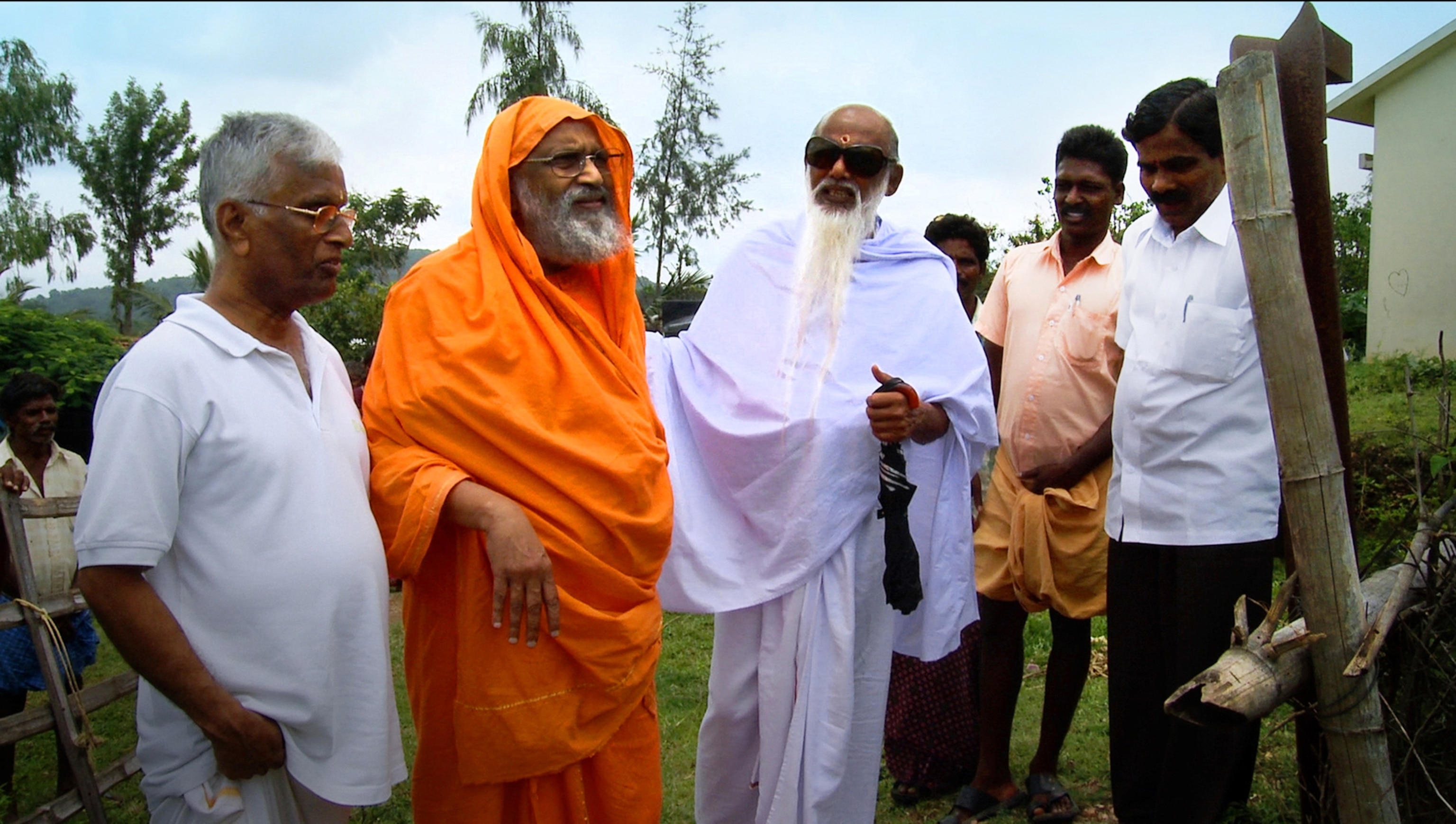Swami Dayananda Saraswati standing in a small group