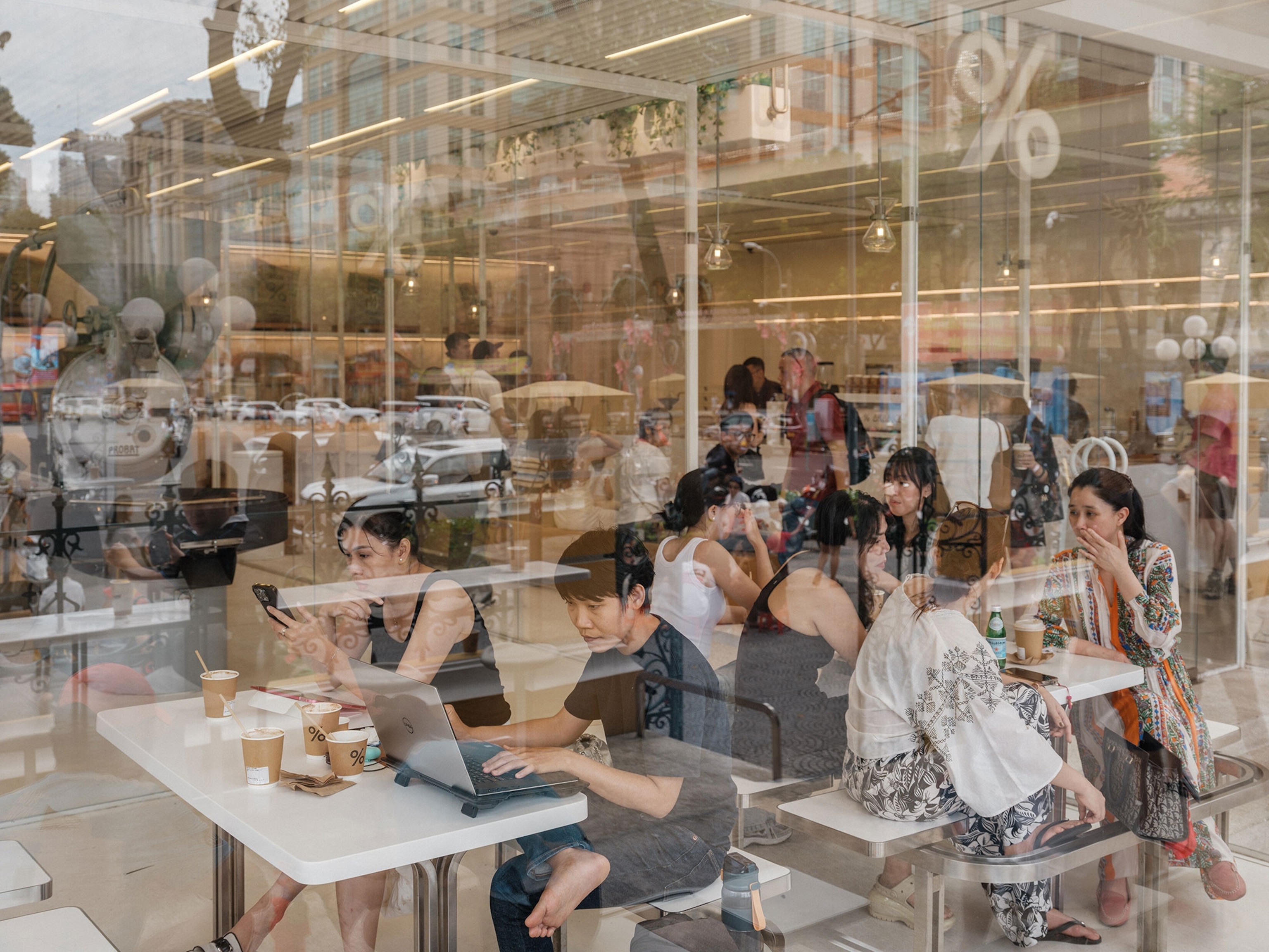 A view through window reflections of customers at a coffee shop in Ho Chi Minh City, Vietnam.