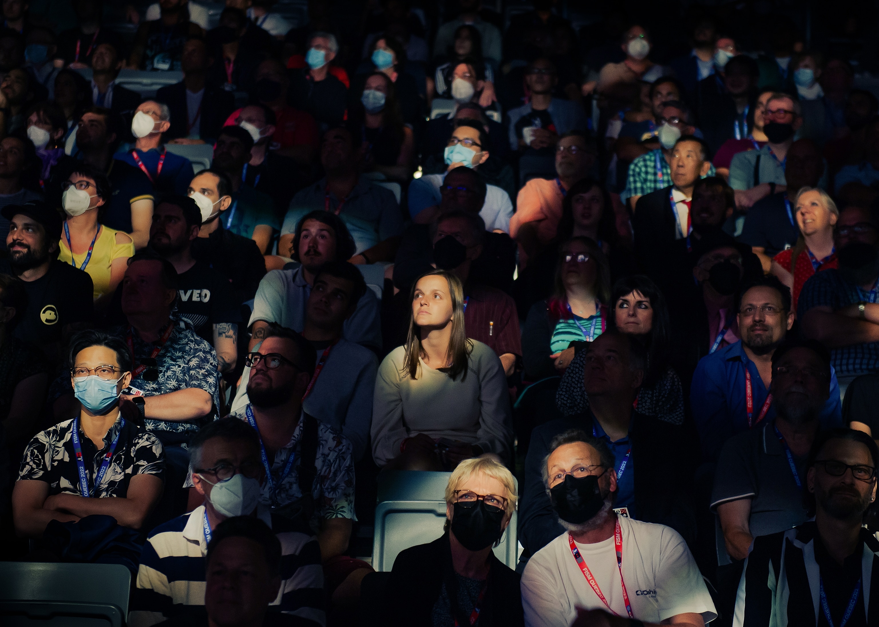 A crowd of people watch magicians perform 