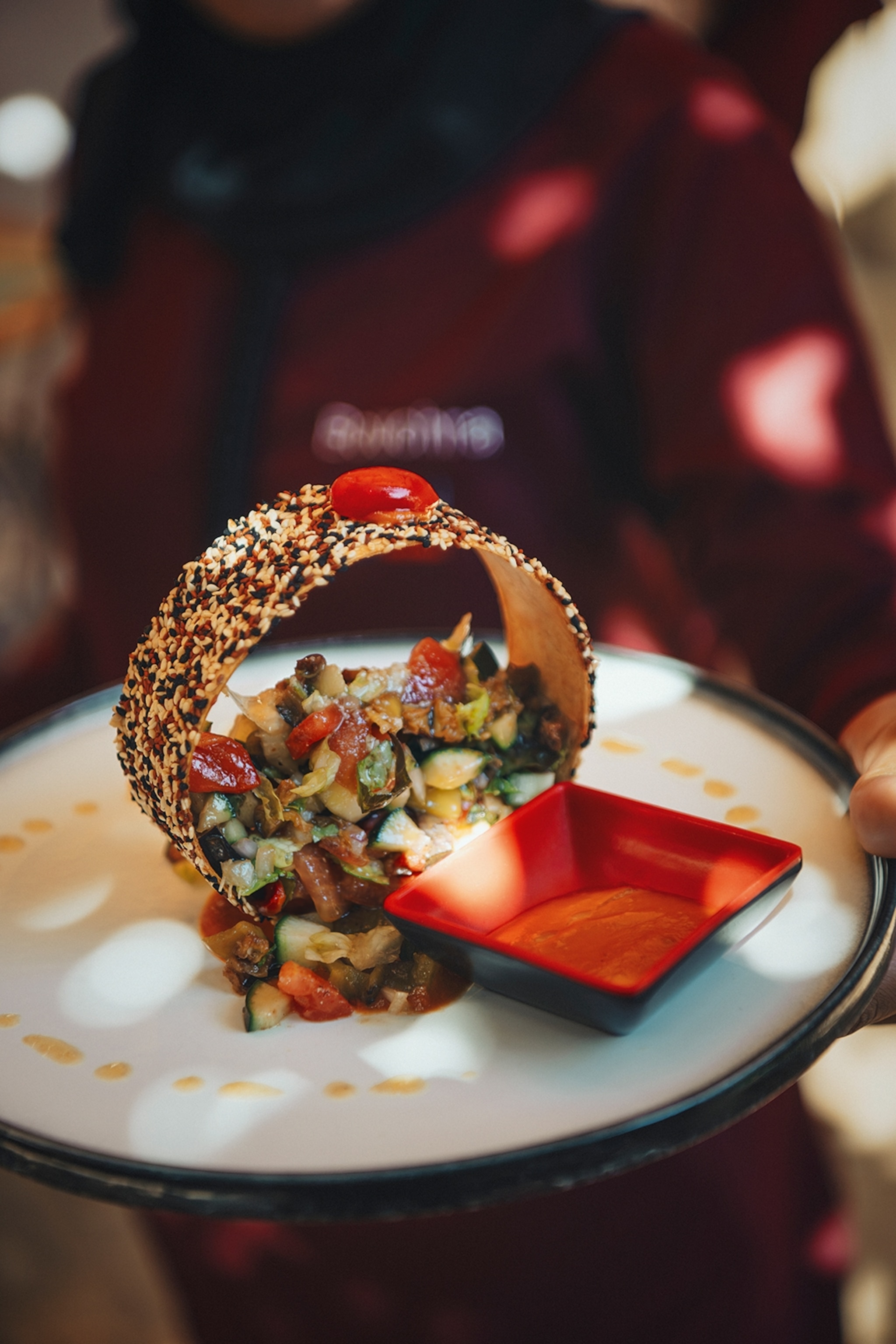 A plate of chopped vegetable salad with seeds in a bread ring.