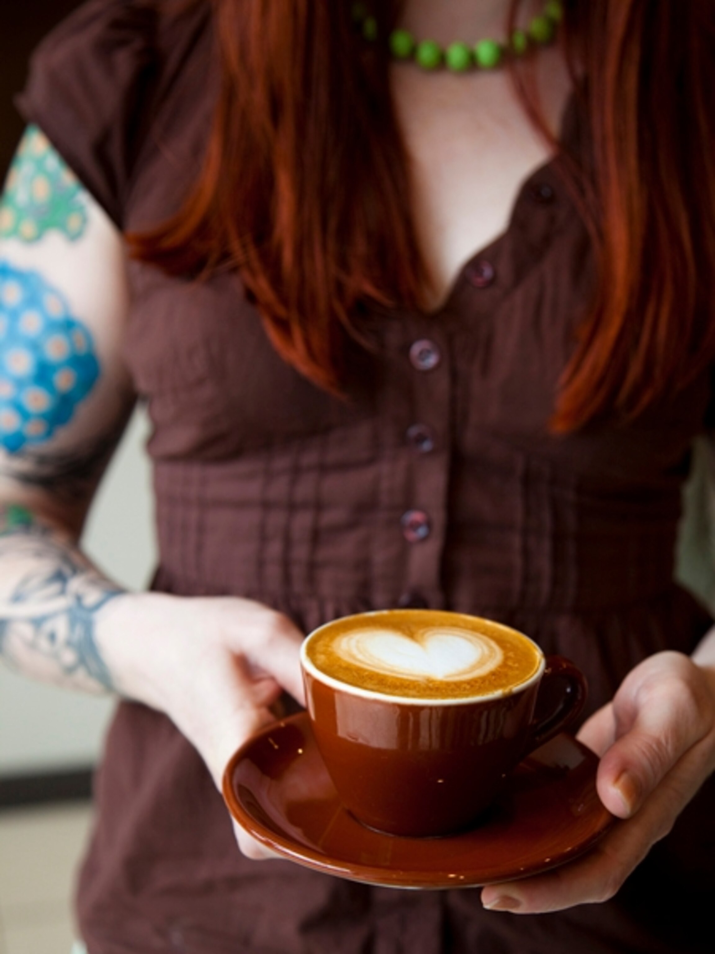 Woman holds cup of coffee, Portland, Oregon