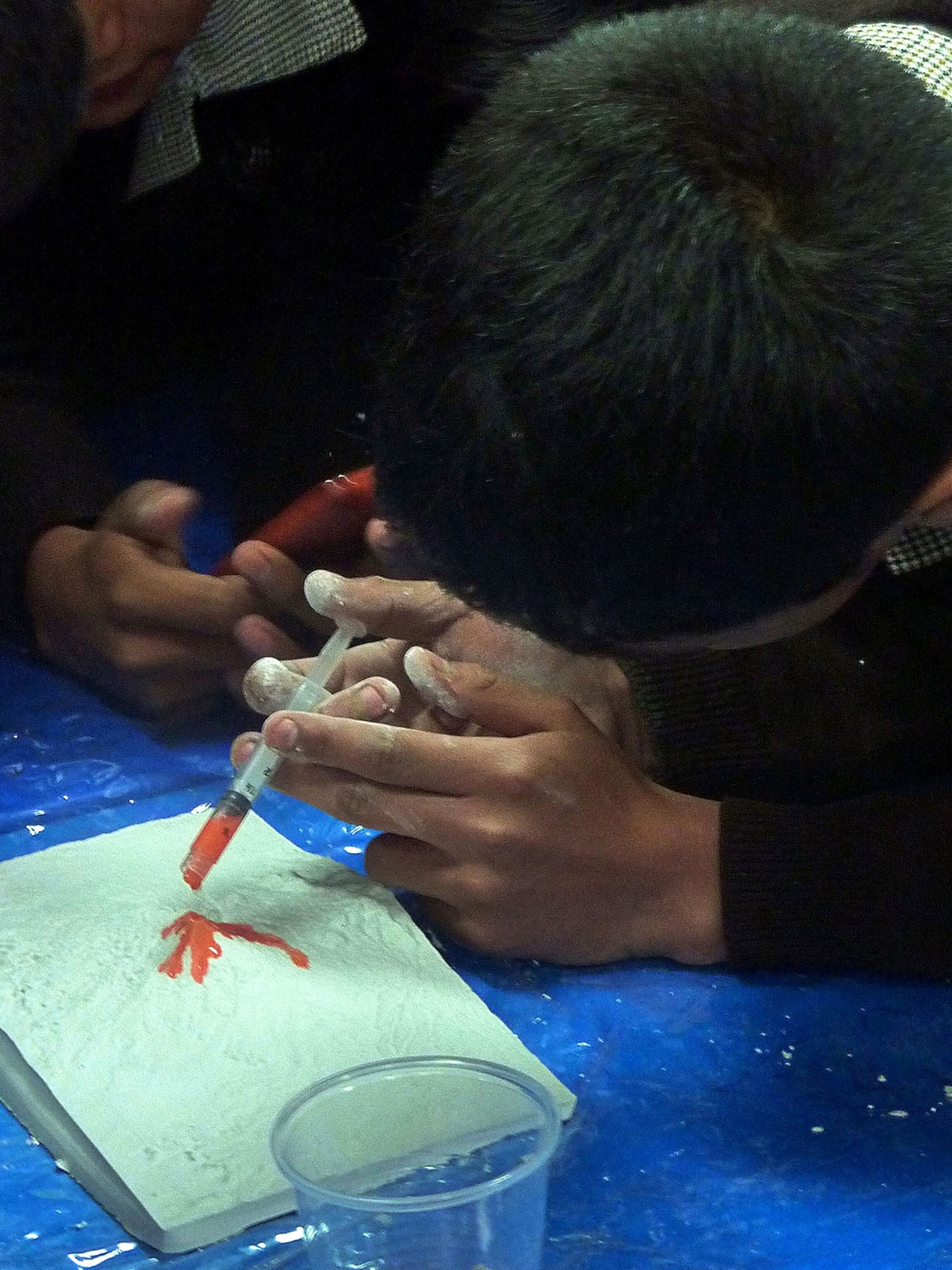 Mexican students simulating lava flow on plaster model