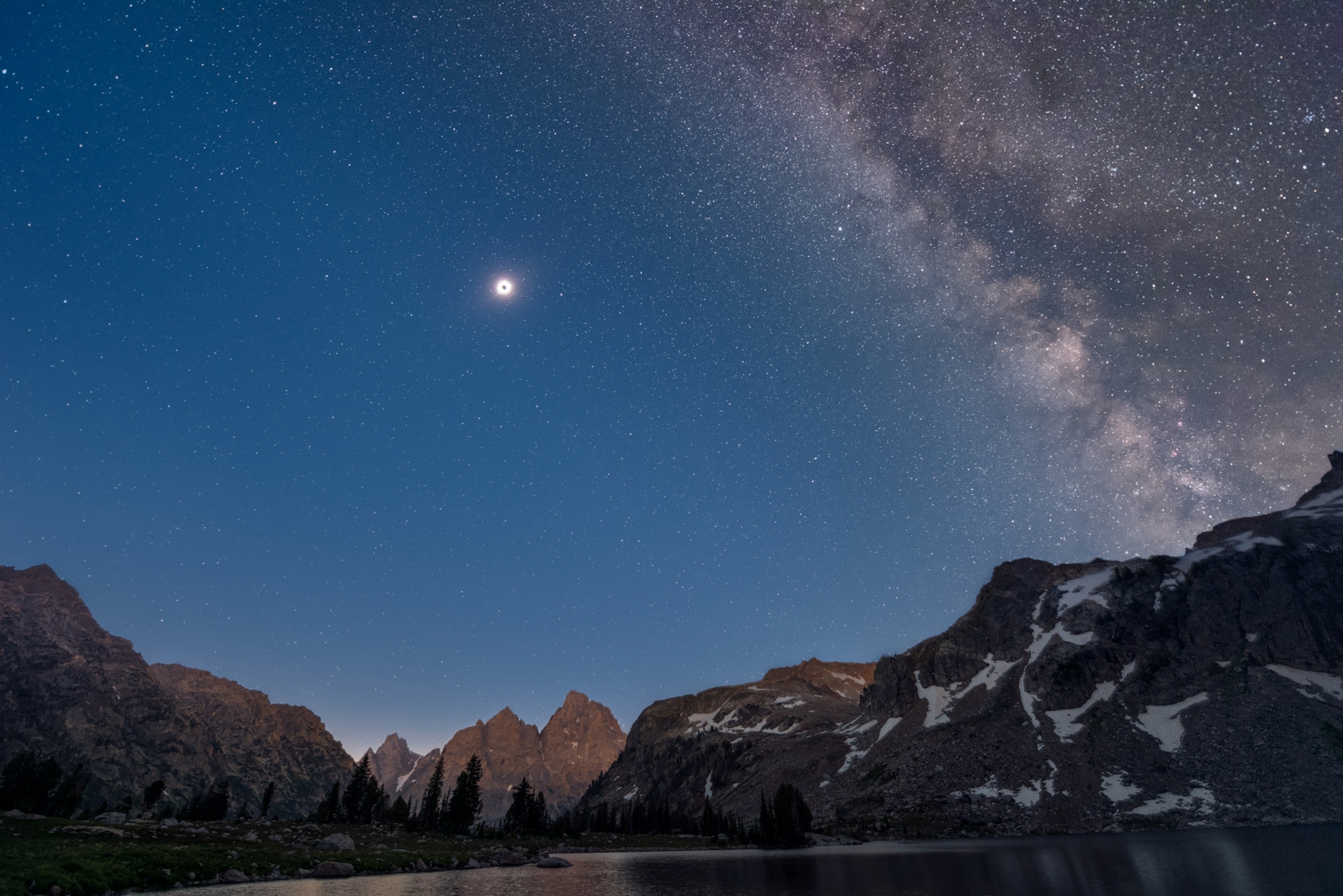 Composite day and night image of the total solar eclipse above Grand Teton mountains and Lake Solitude.