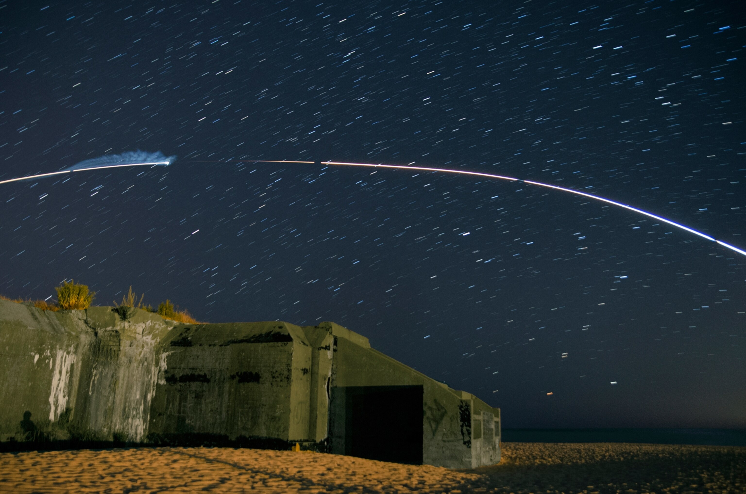 Minotaur V rocket arcing above World War II bunker in New Jersey