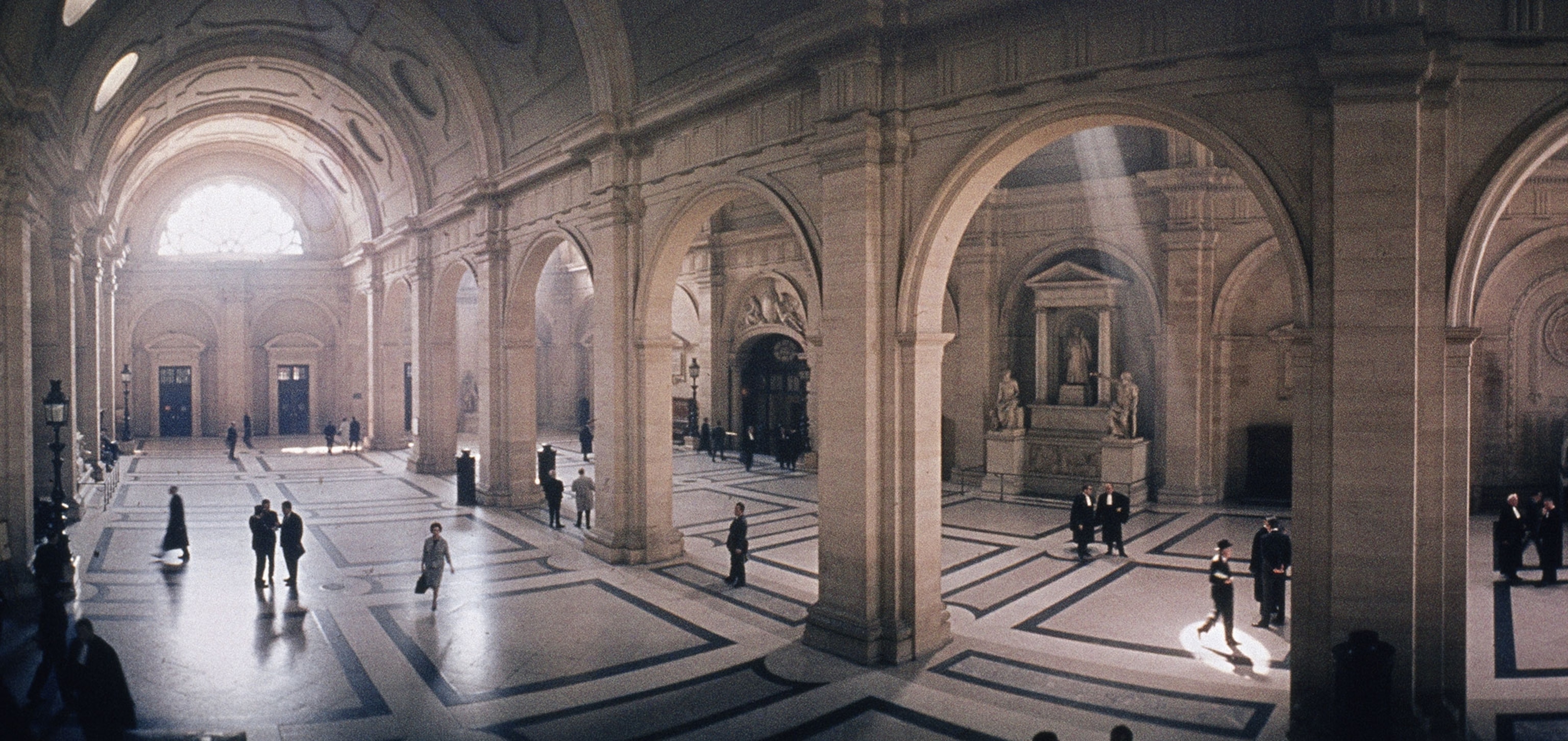 people in a large room with columns