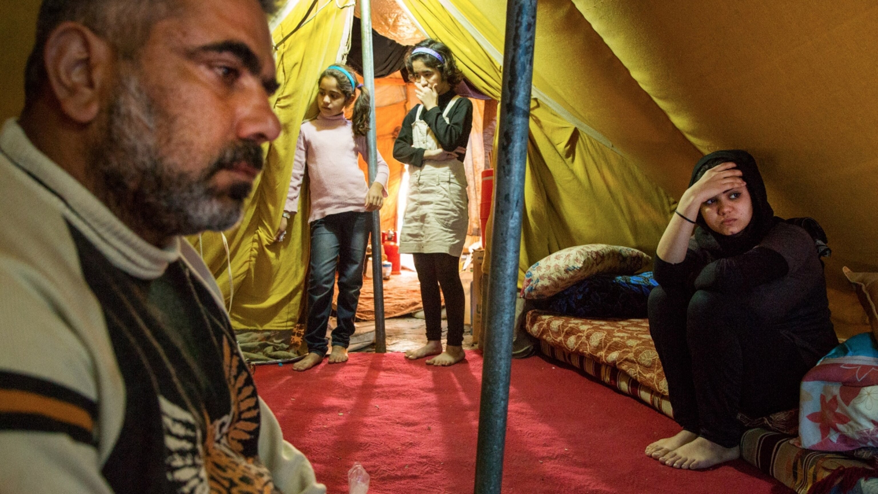 Jihan, 16, sits anxiously in the family tent at the Domiz camp for Syrian refugees outside of Dohuk, Iraq. With her are her father Mohammed, 42, and her sisters Viyan, 13, and Laylan, 10.
