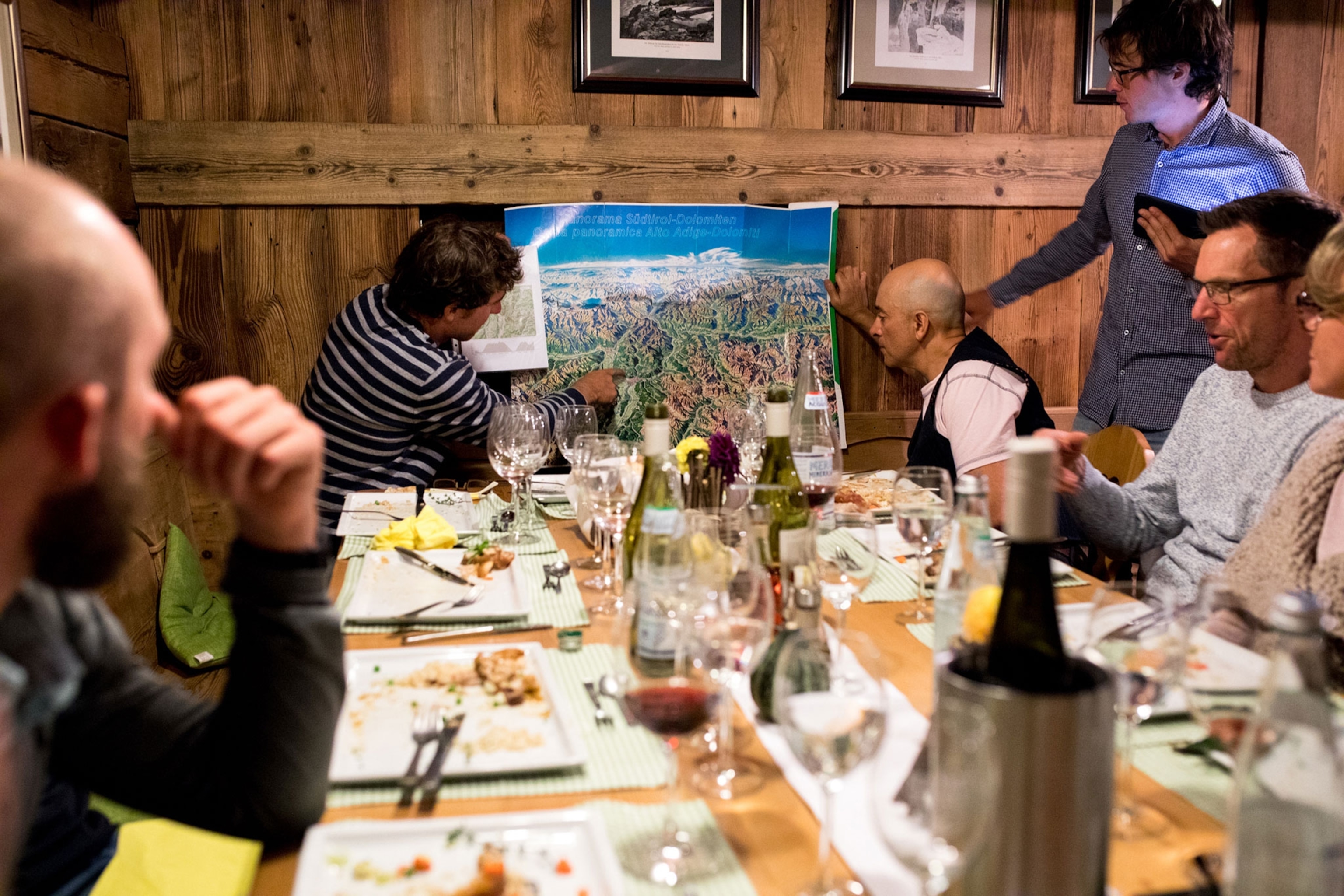 a group of cyclists at dinner looking over their maps for the next days ride