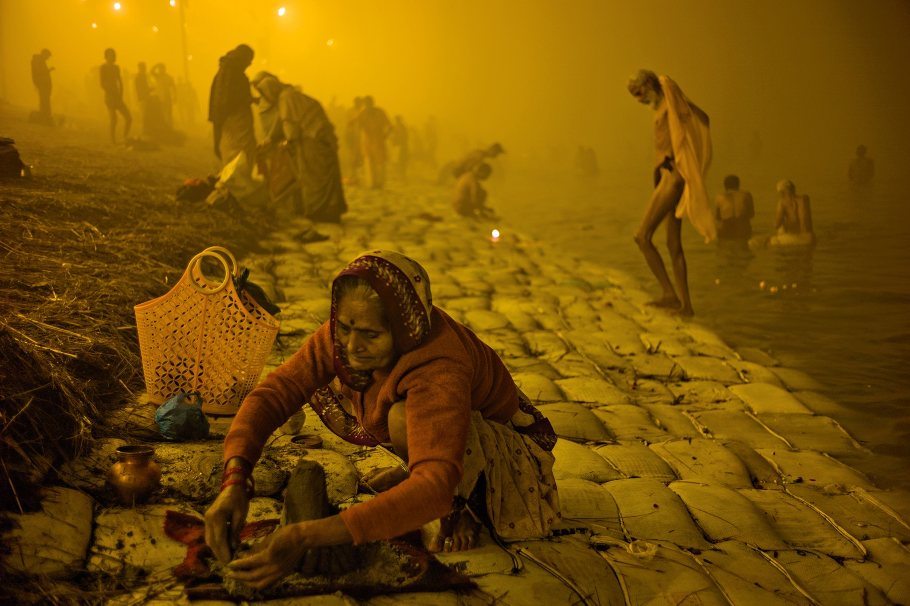 Before dawn an old woman performs puja, a ritual offering to the gods. The most devout pilgrims are often elderly. They come for the entire festival and renounce all comfort while there.