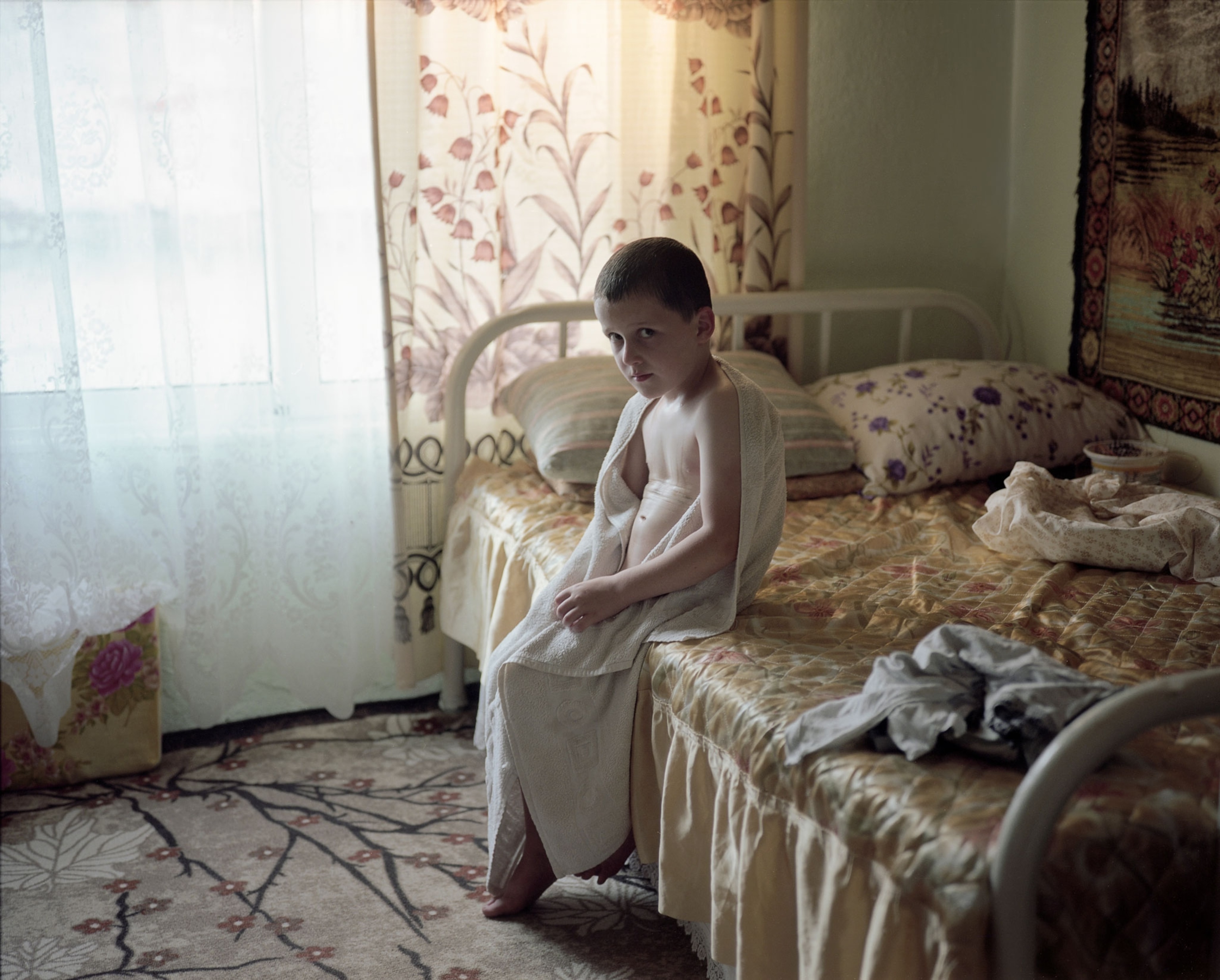 a Pomak boy sitting on his bed