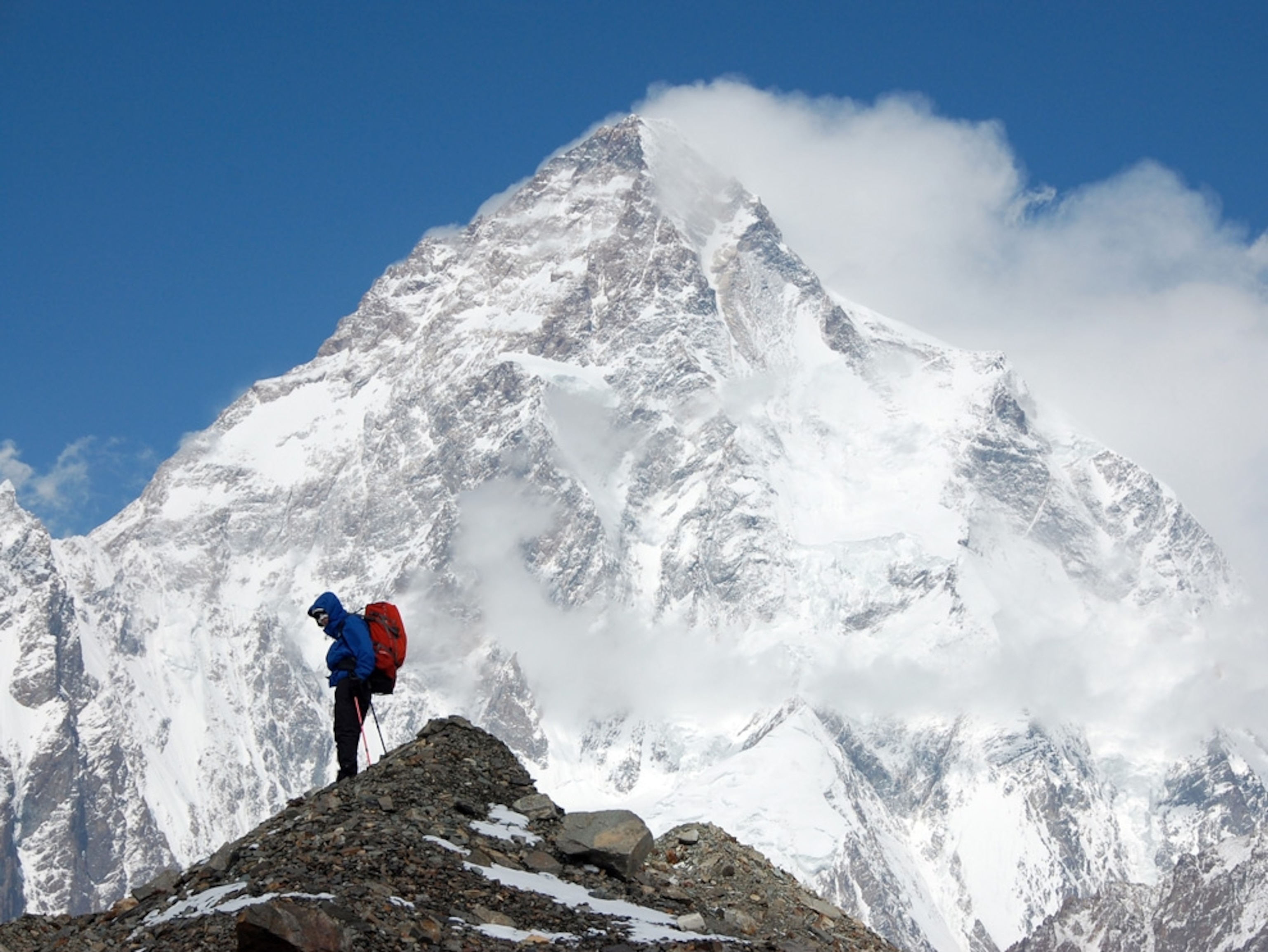 A climber in front of a snowcapped mountain